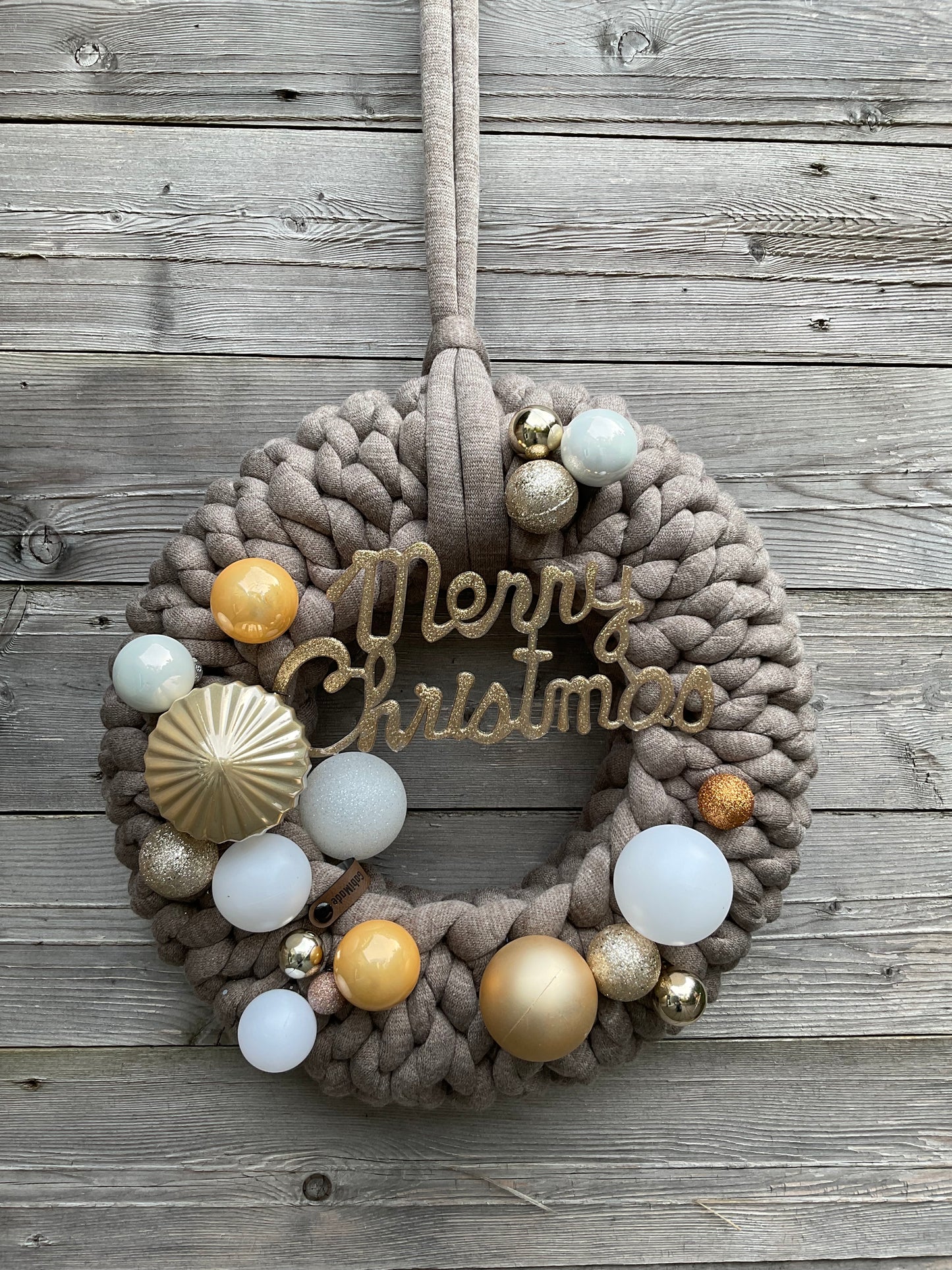 Ein gestrickter brauner geschmückter Türkranz