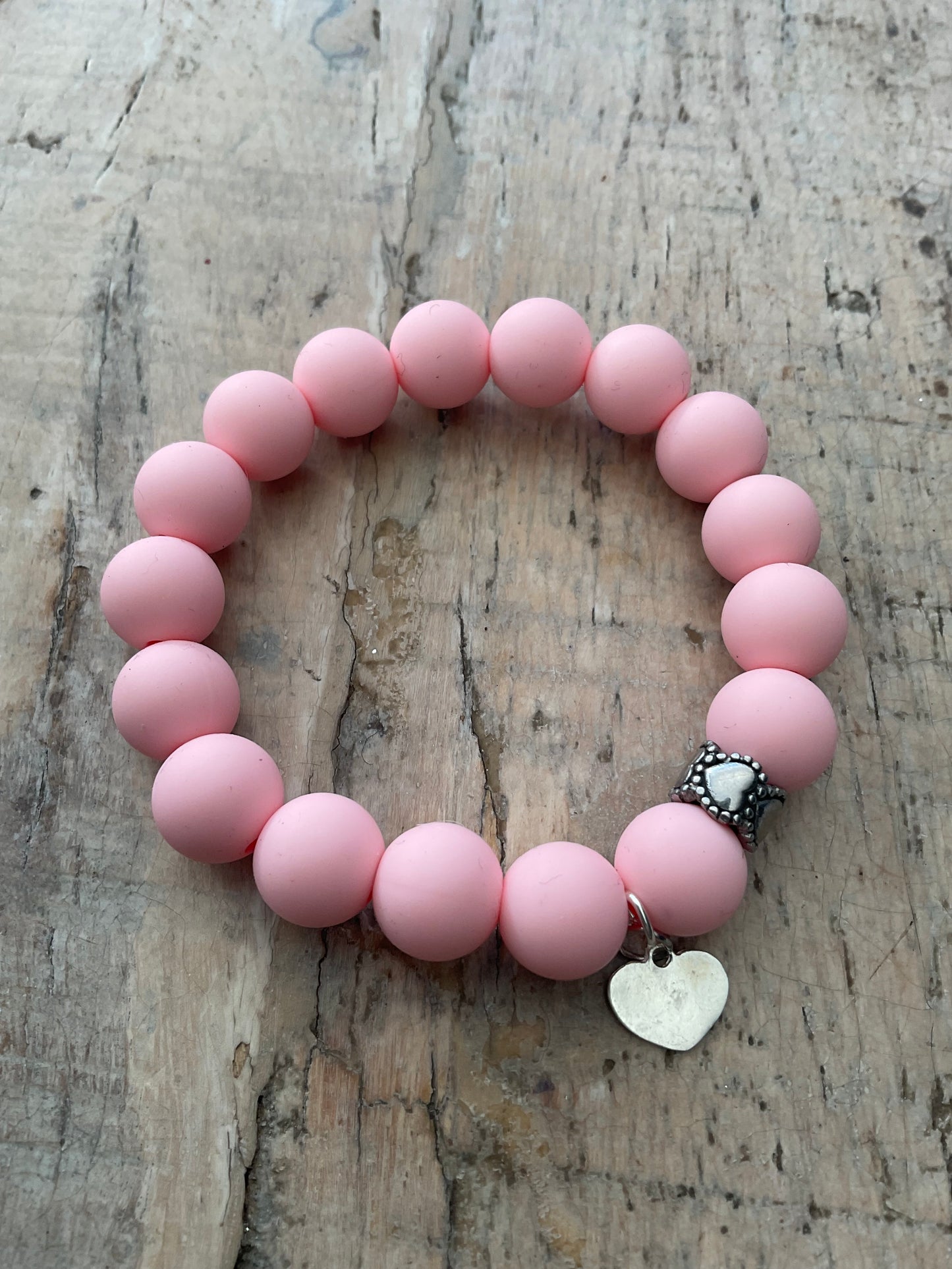 Ein Armband aus rosa Silikonperlen und Herzanhänger