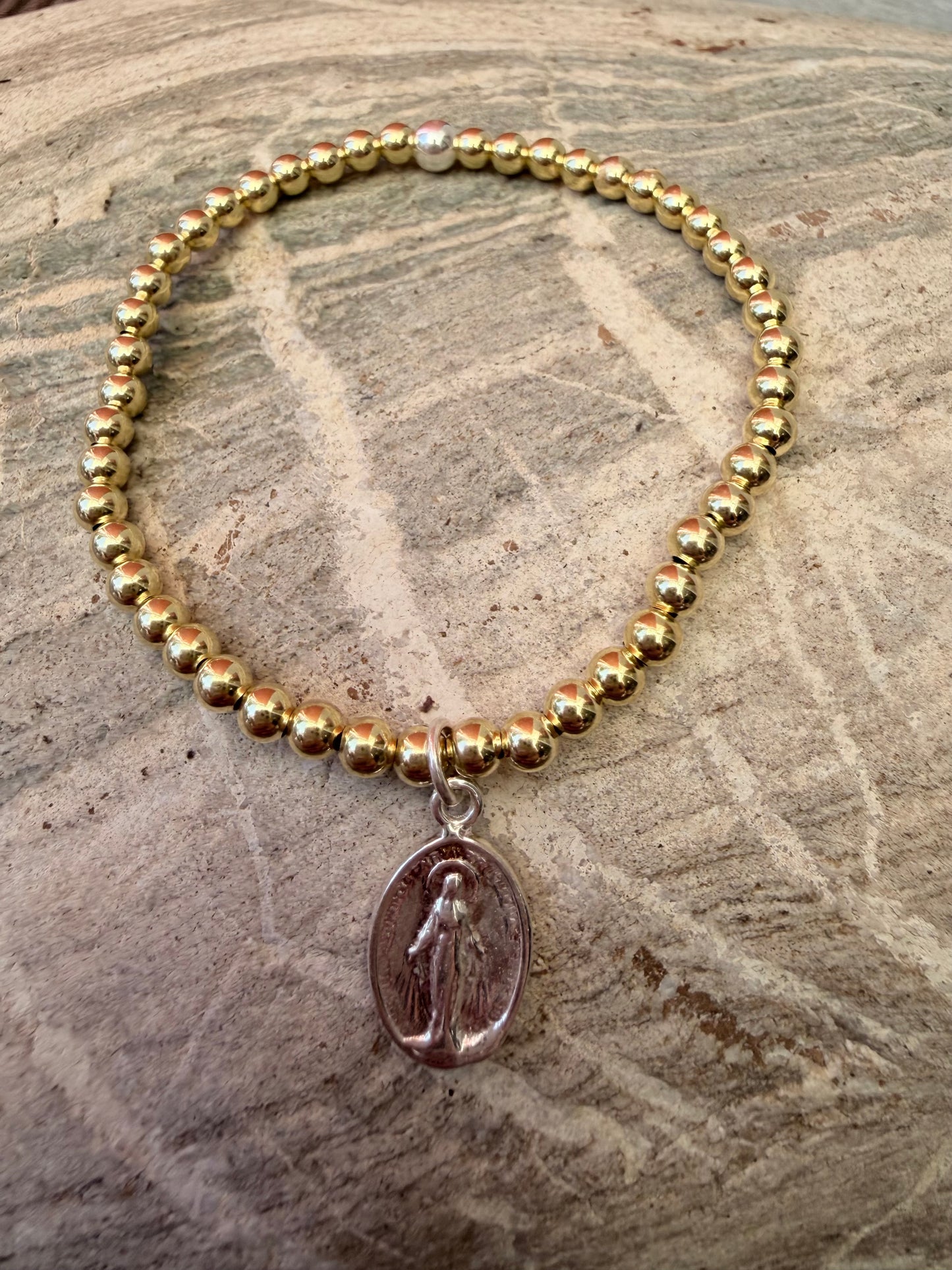 Ein vergoldetes Perlenarmband mit Madonnen Anhänger