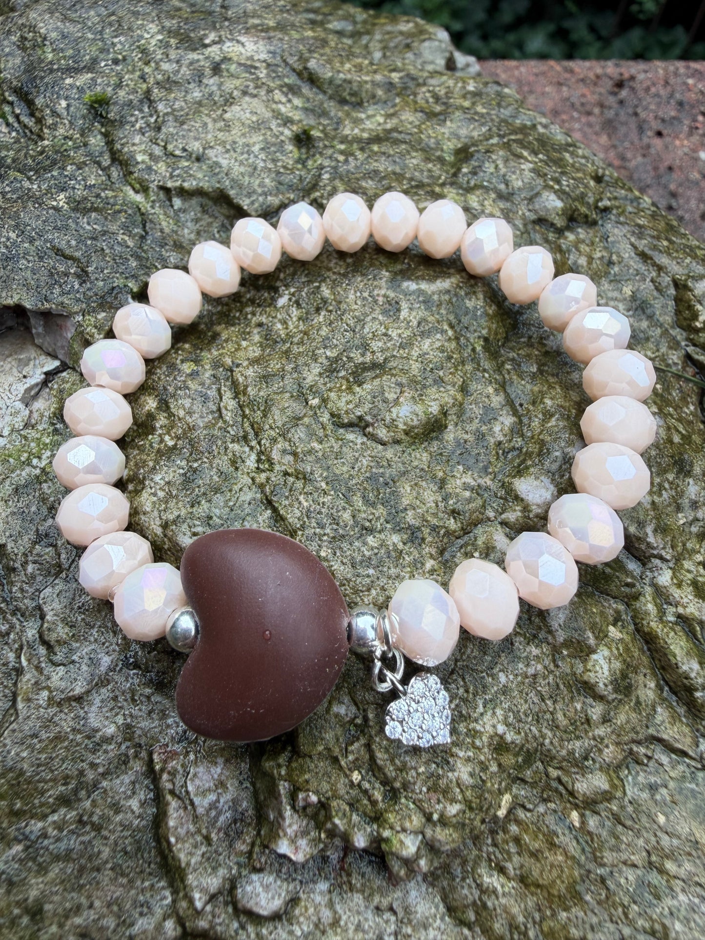 Ein champagberfarbenes Armband mit braunen Herz