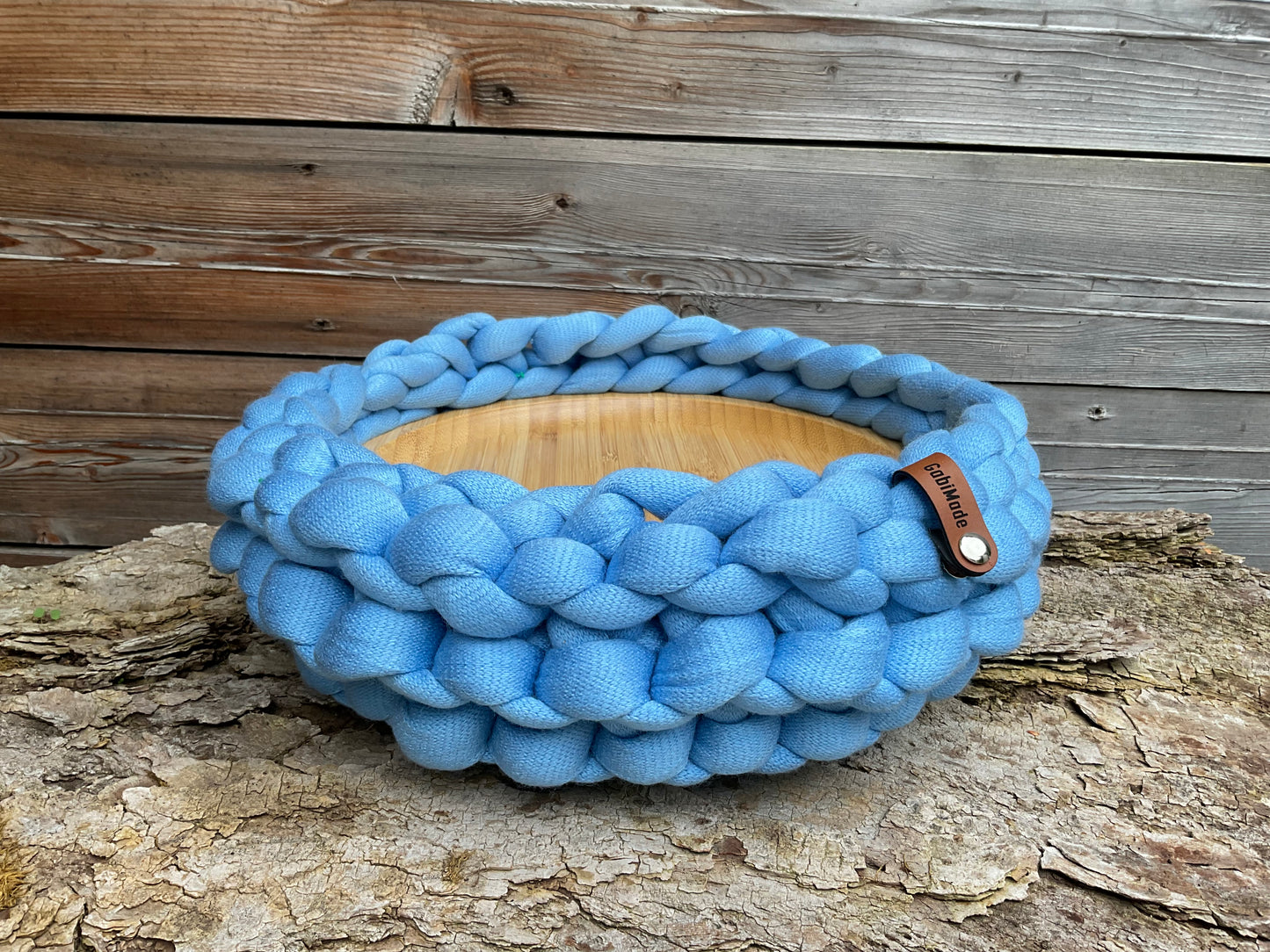 Ein gestricktes blaues Tablett mit Holzbrett