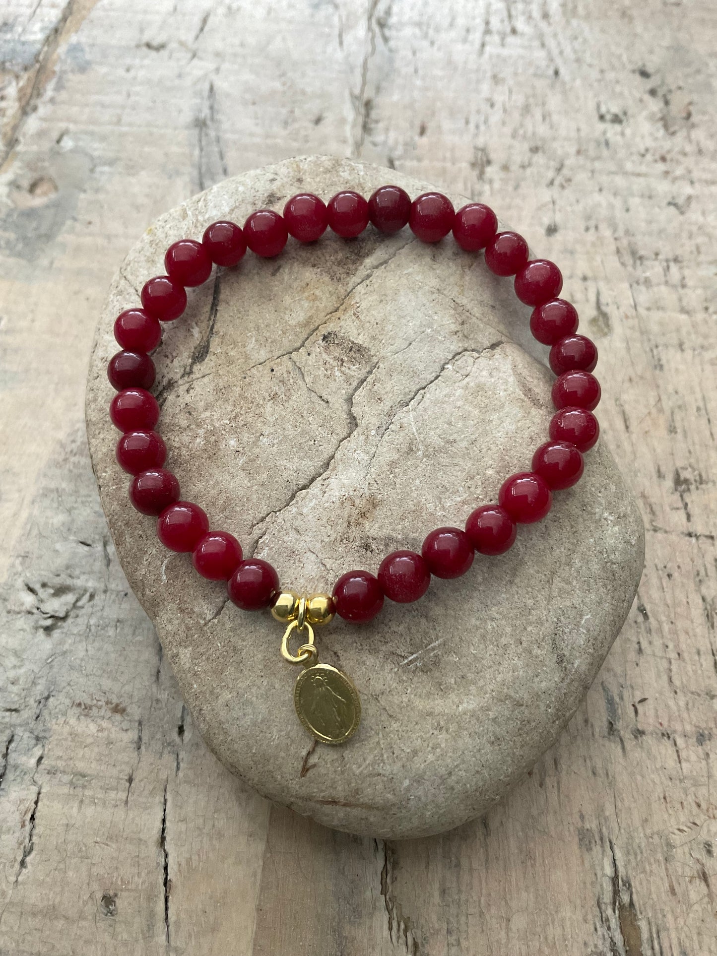 Ein Perlenarmband mit goldenen Madonna Anhänger