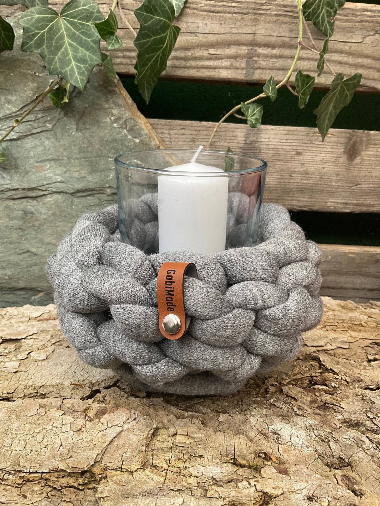 Ein gestricktes braunes Windlicht mit Glaseinsatz