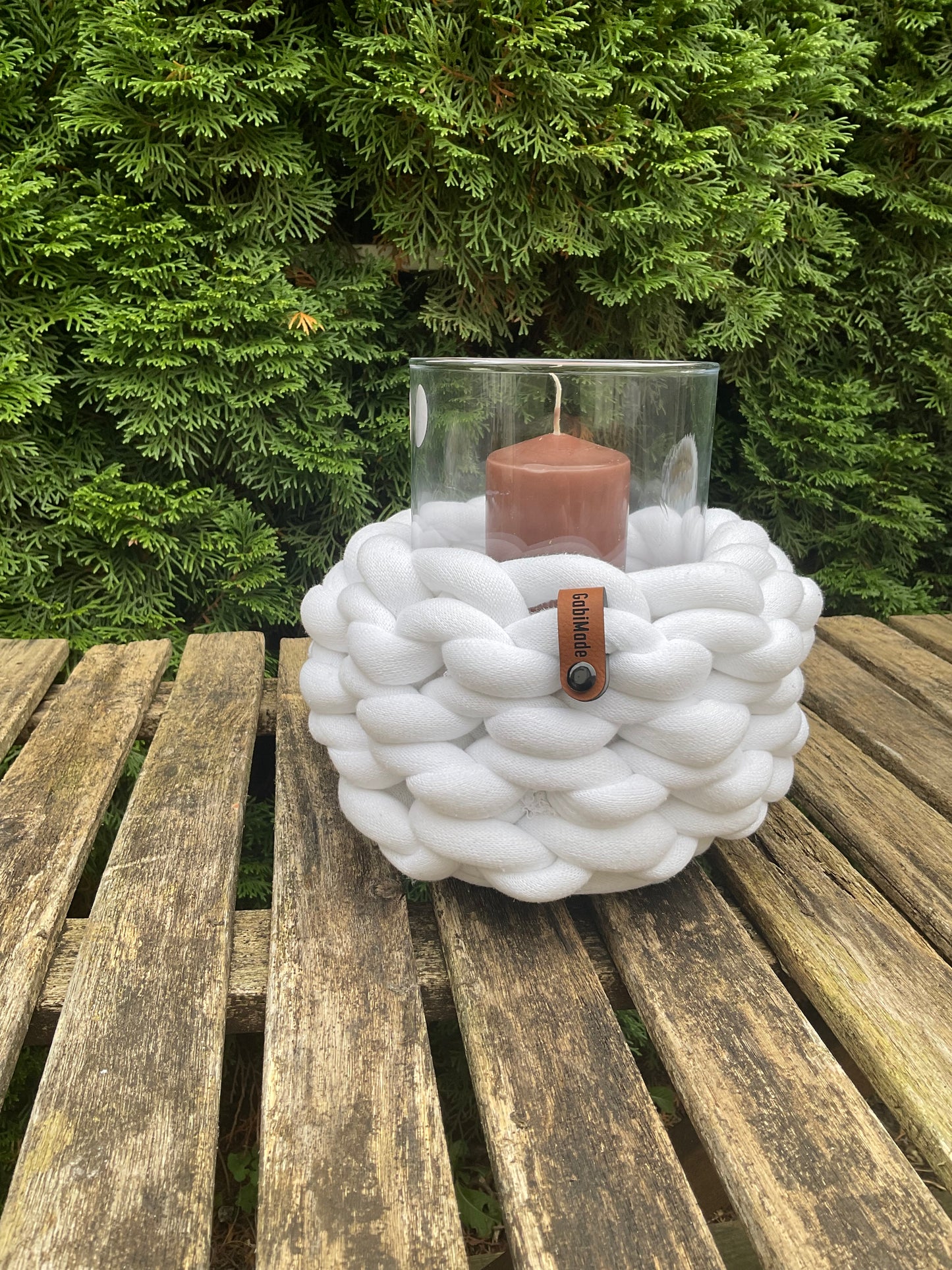 Ein gestricktes weißes Windlicht mit Glaseinsatz