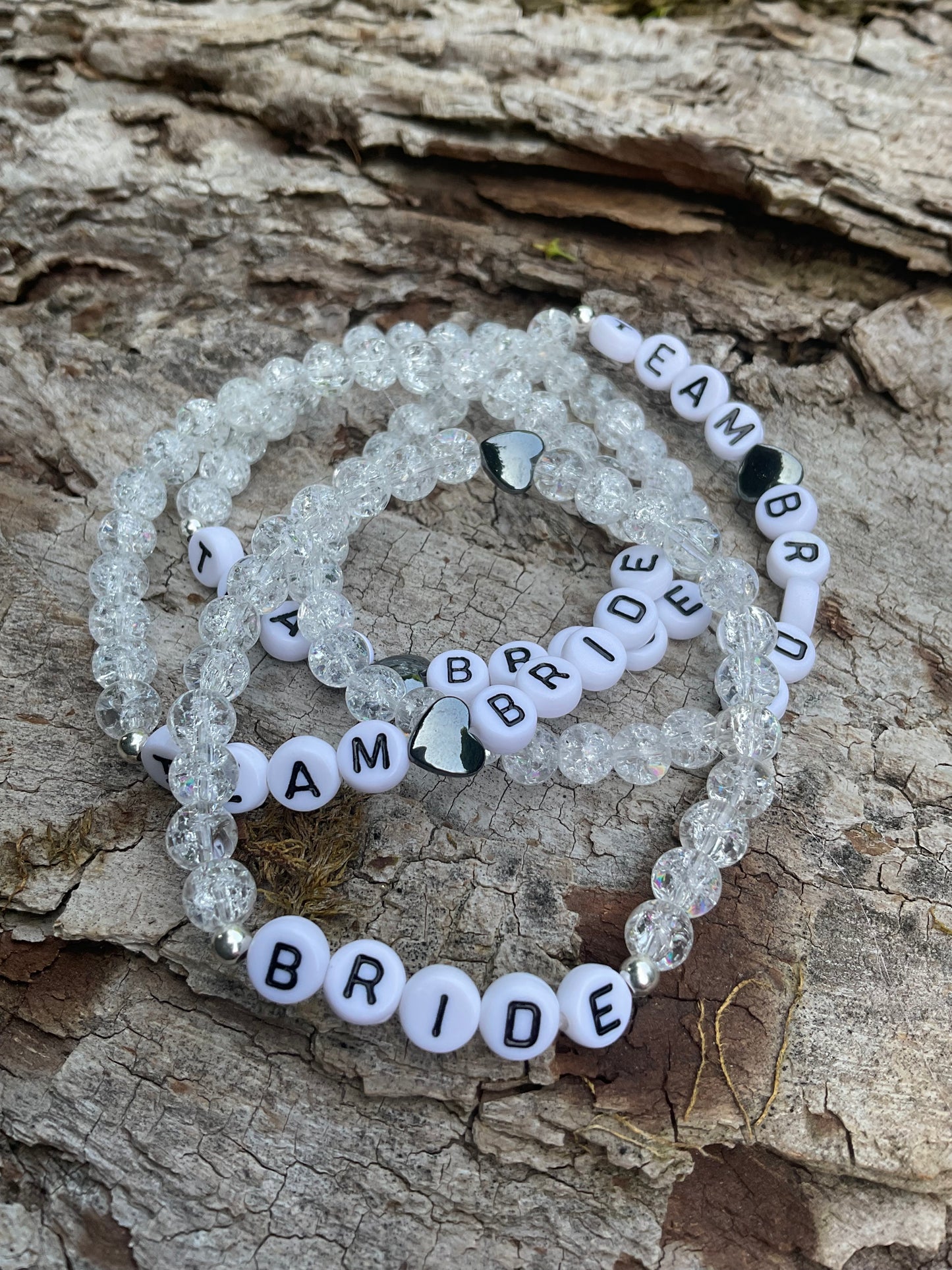 Ein 4er Set Armbänder aus weißen CrashPerlen mit den Worten Bride und Team Bride