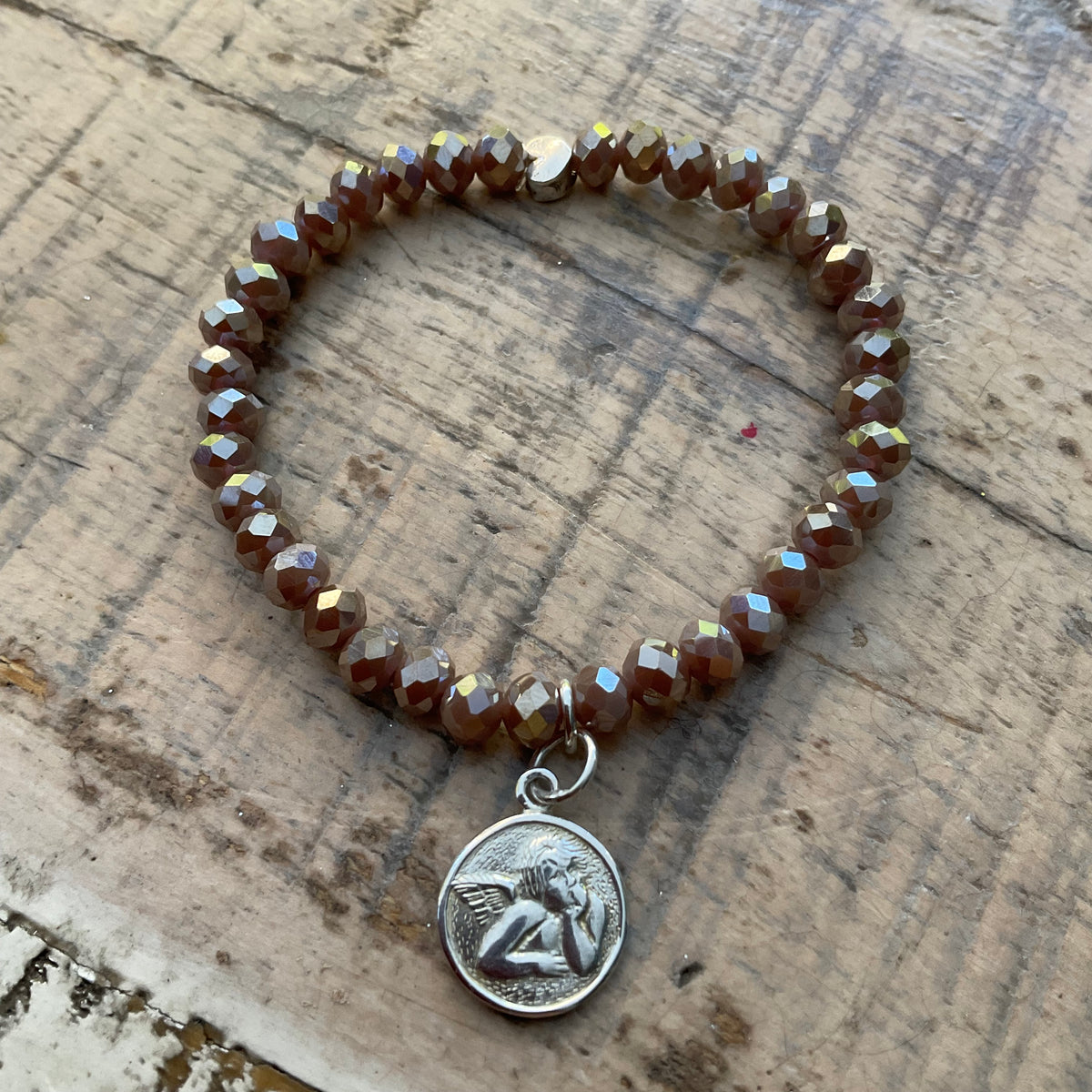 Ein braunes Perlenarmband mit Schutzengel und Herzperle