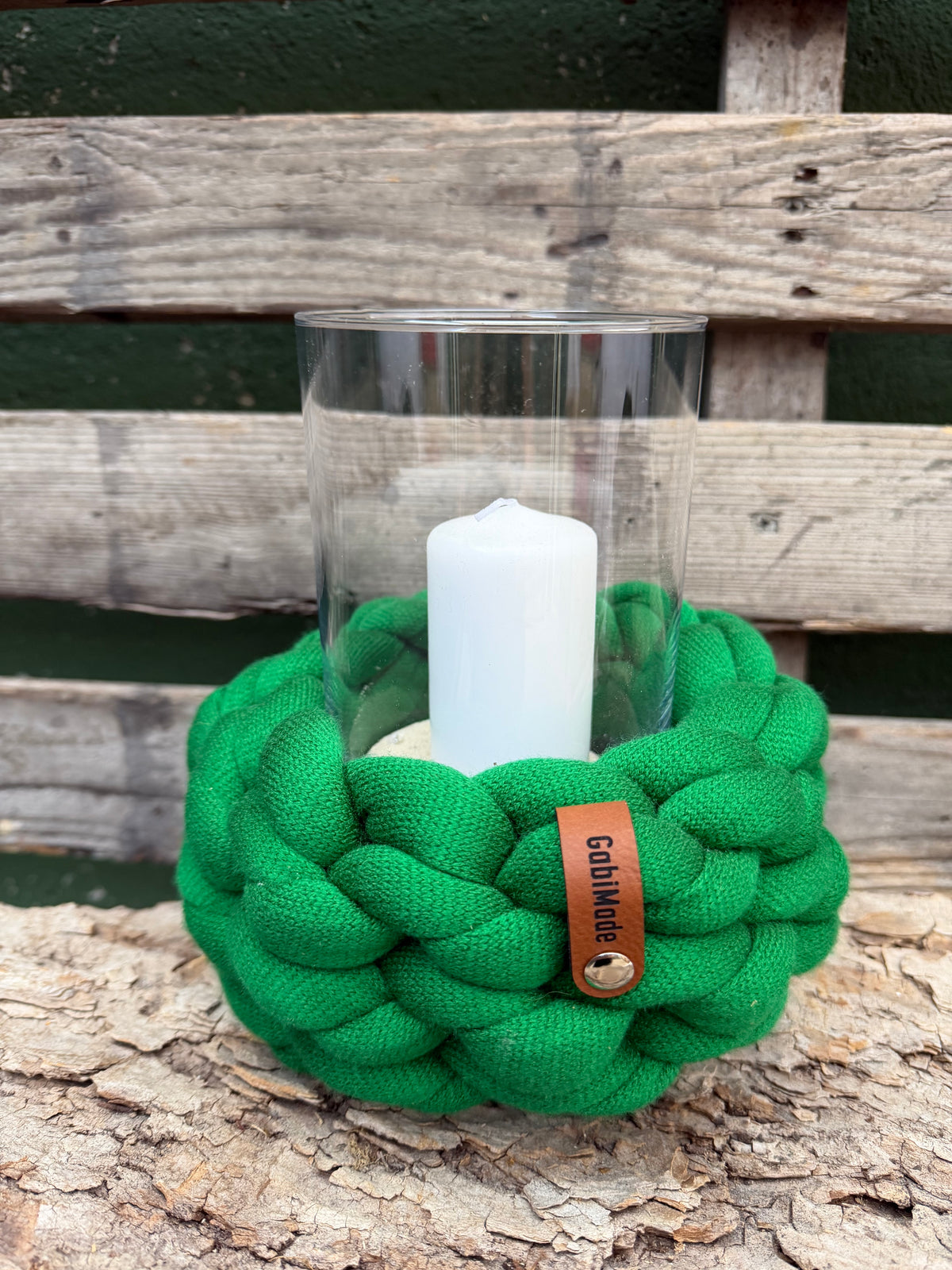 Ein gestricktes grünes Windlicht mit Glaseinsatz