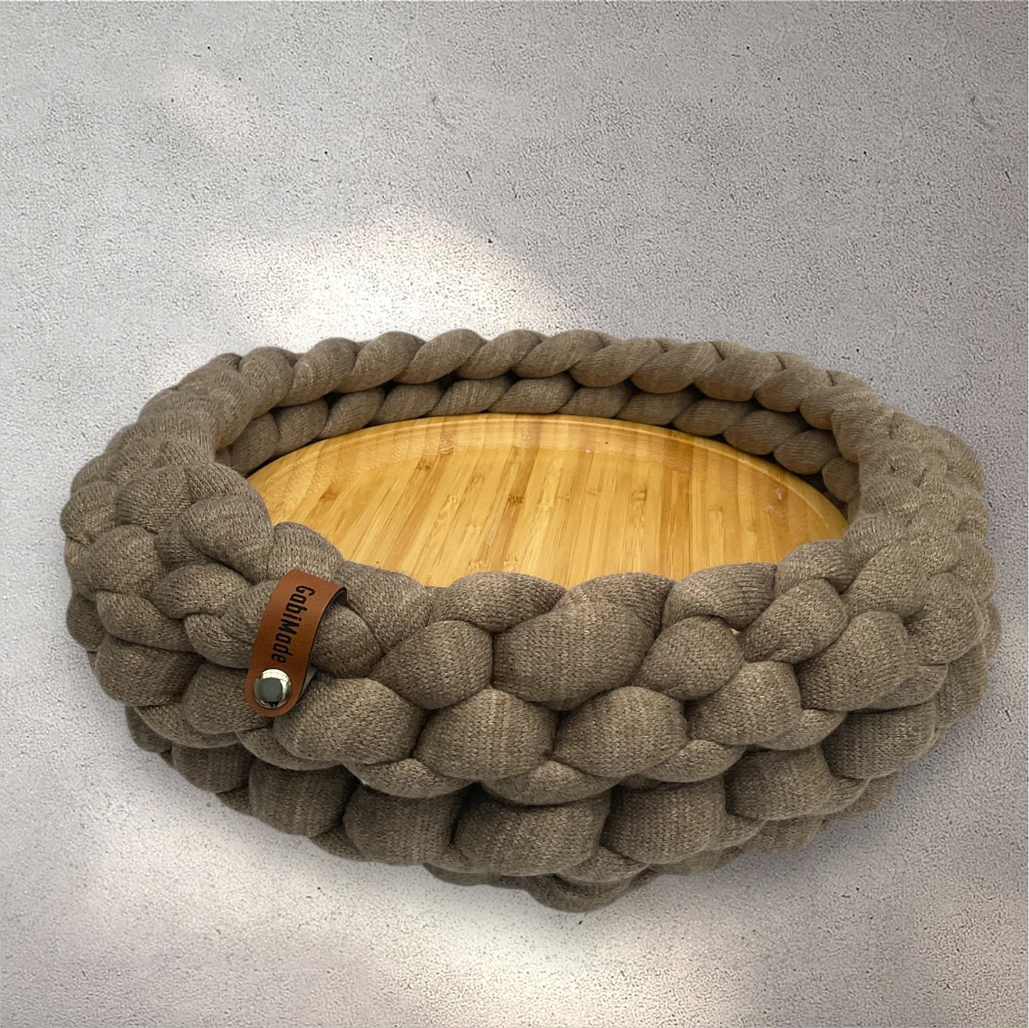 Ein gestricktes braunes Tablett mit Holzplatte