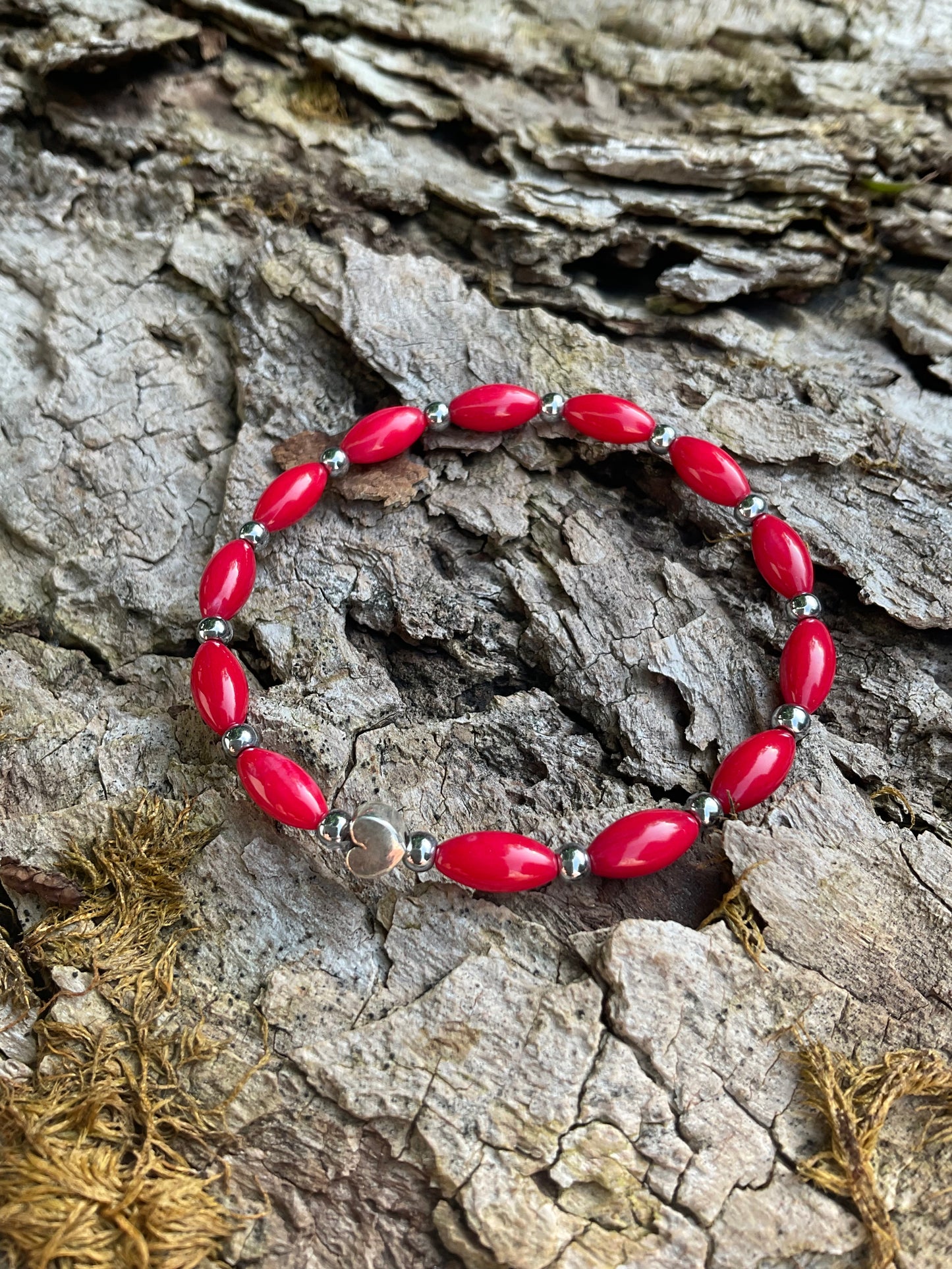 Ein rotes Perlenarmband mit einem Silberherz