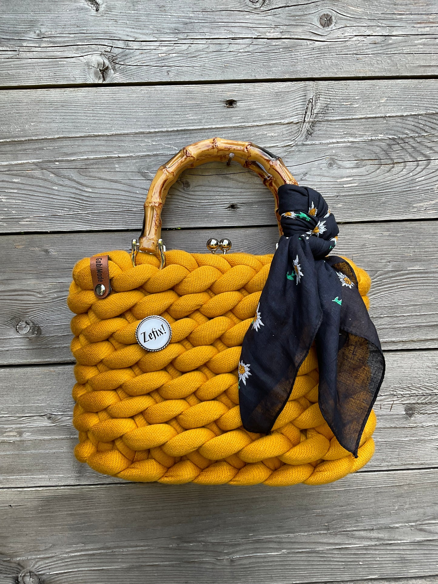 Eine gestrickte safranfarbene Tasche mit Tuch