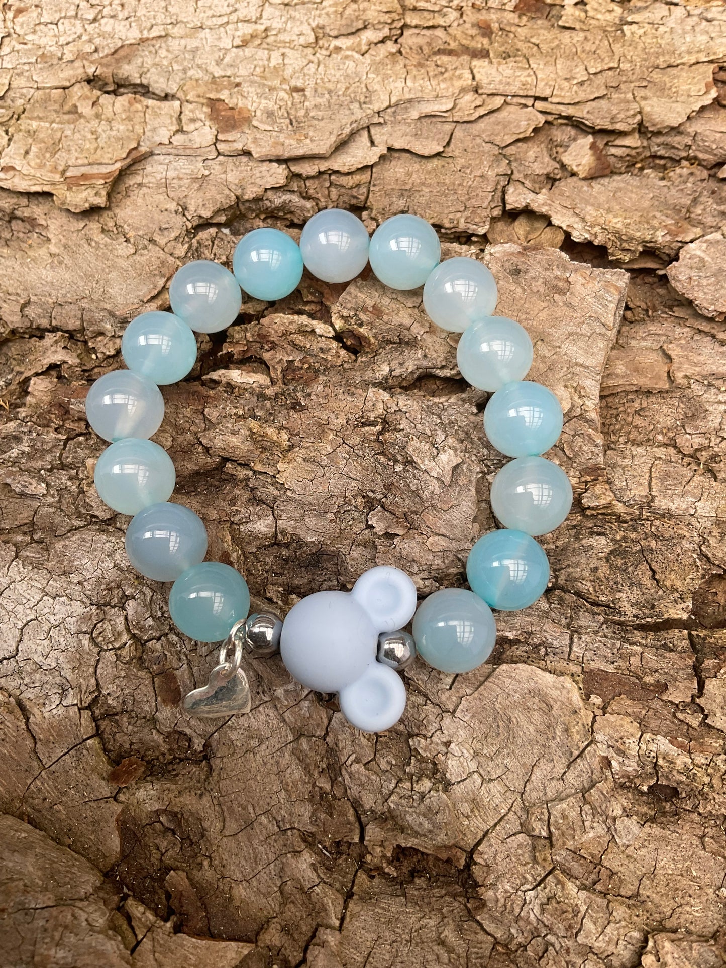 Ein hellblaues perlenarmband mit MickeyMouse und Herz