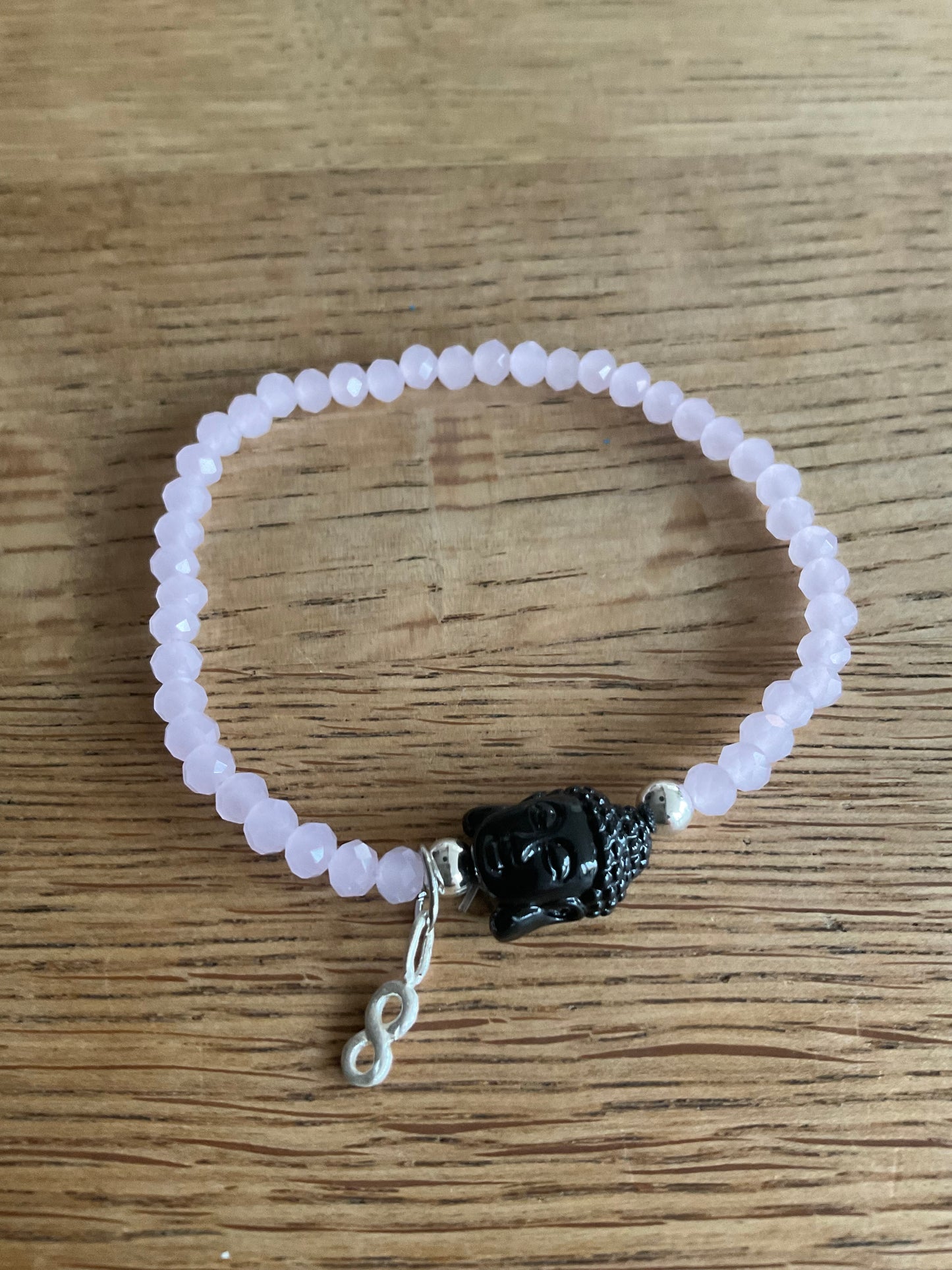 Ein rosa perlenarmband mit Buddha und Anhänger