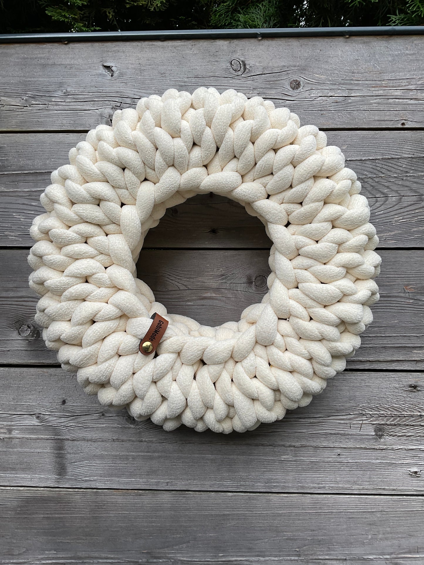 Ein gestrickter Kranz in Cremeweiß
