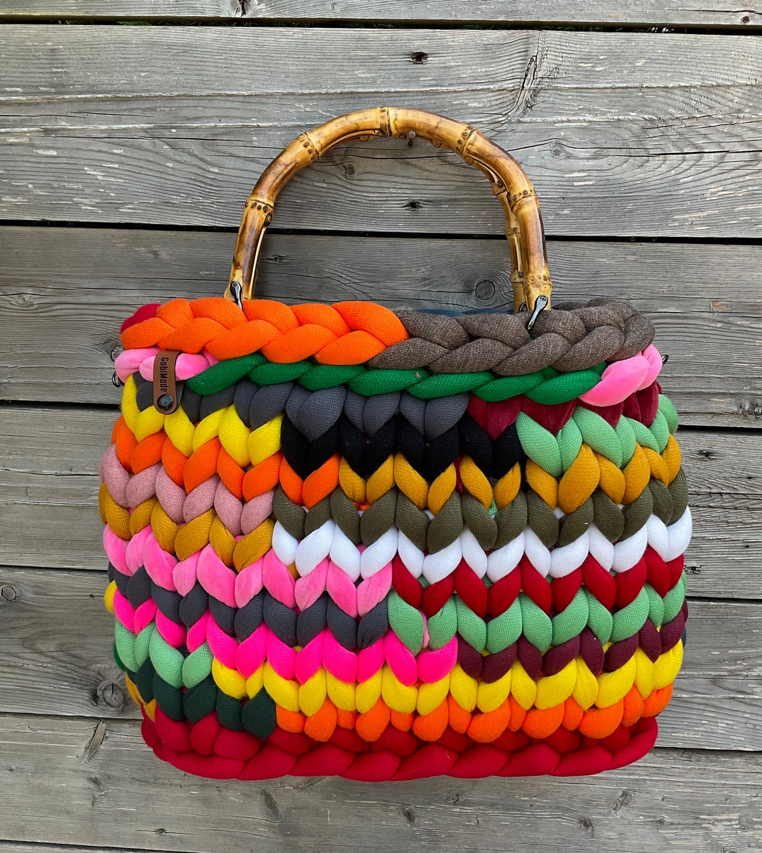 Eine gestrickte bunte Tasche mit Bambusgriffen
