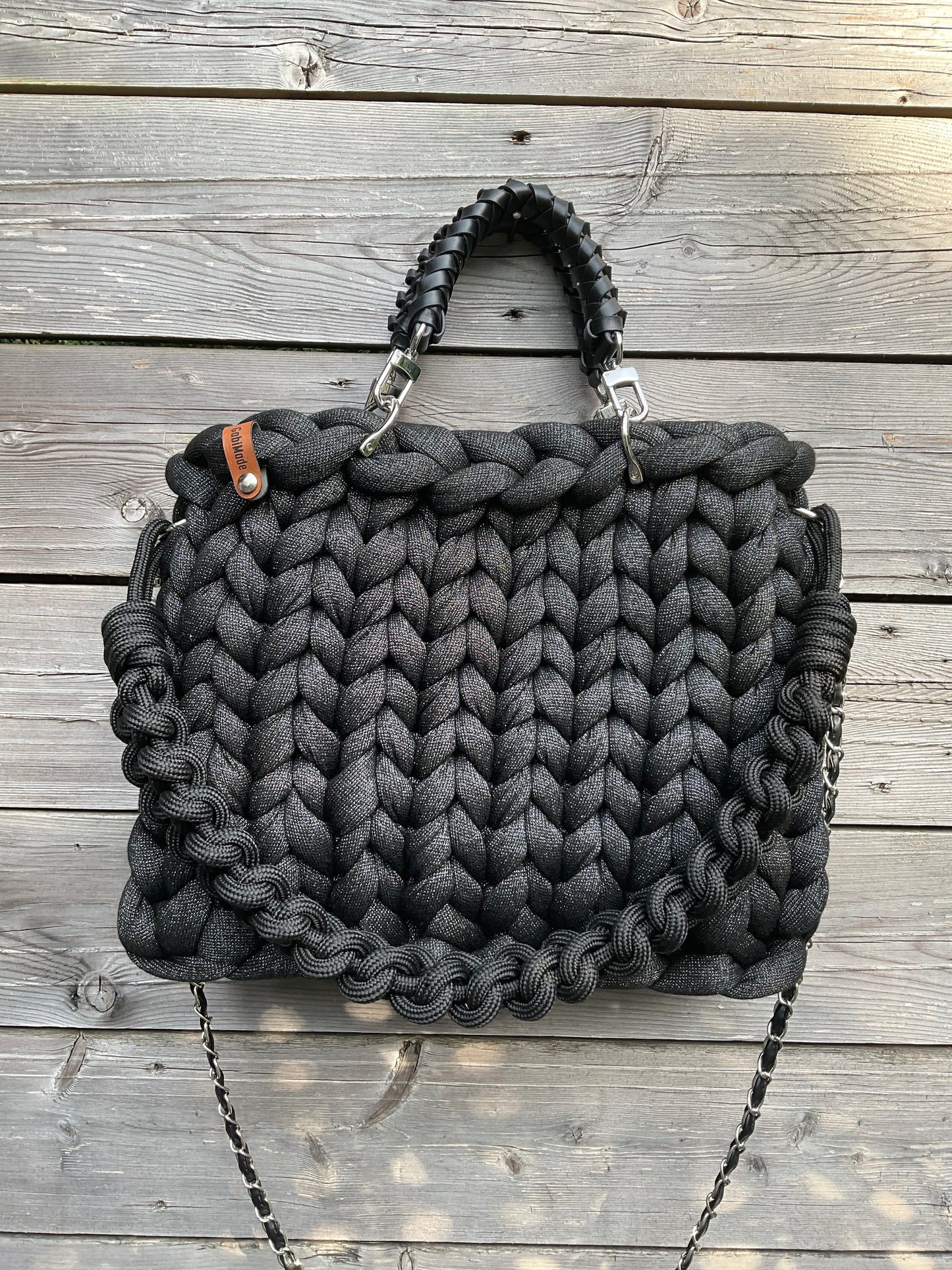 Eine gestrickte schwarze Tasche mit Lurexfäden