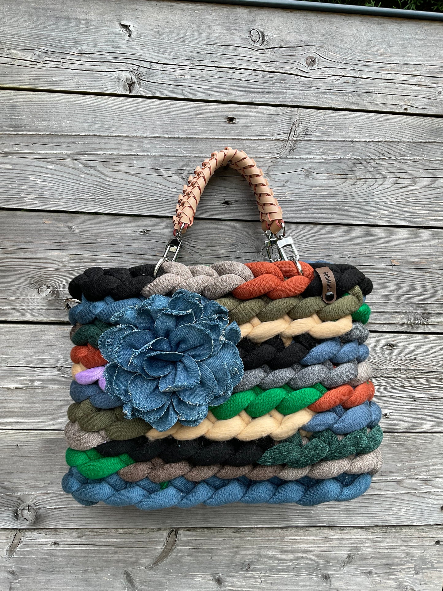 Eine gestrickte bunte Tasche mit Ledergriffen