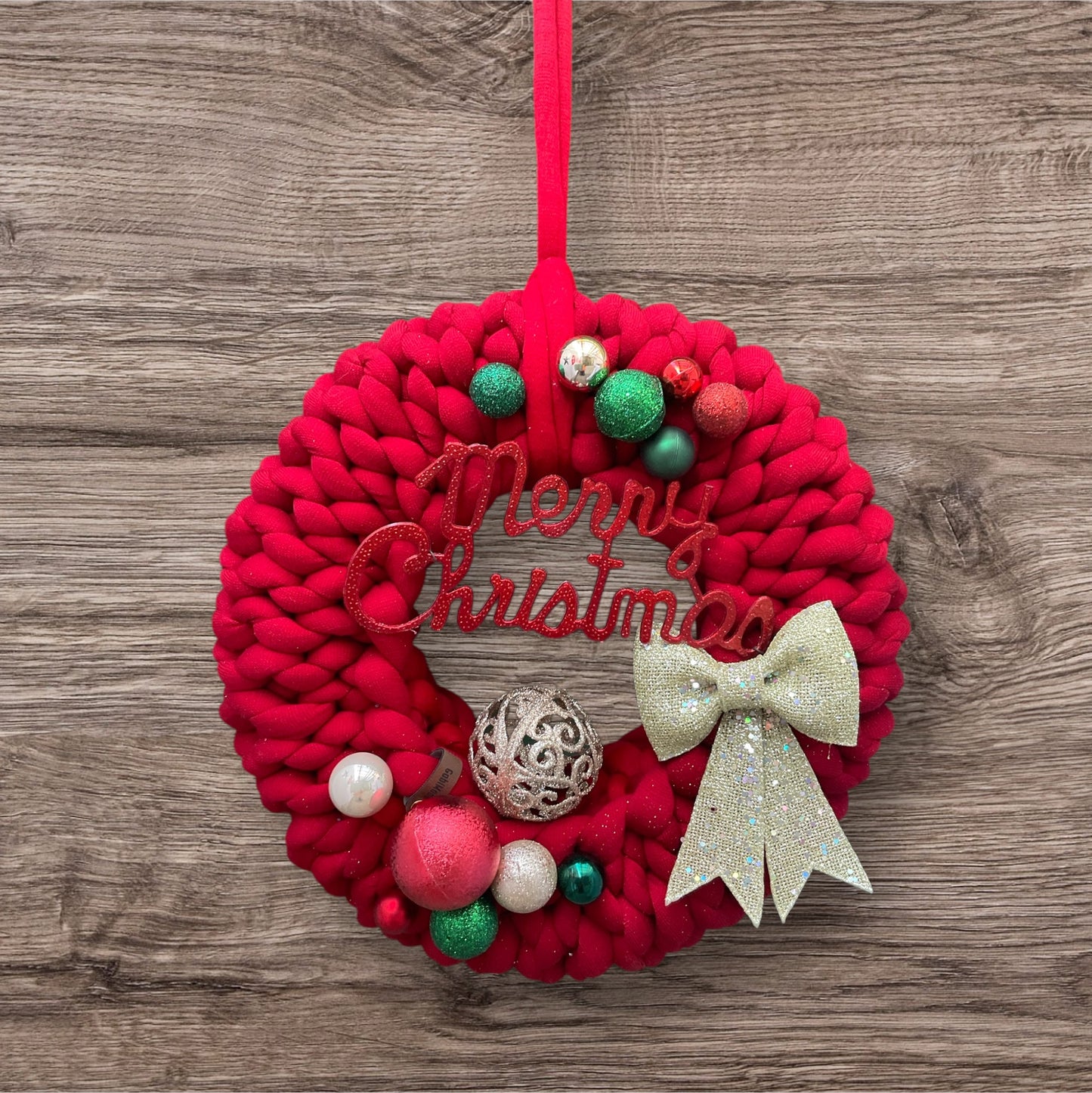 Ein roter gestrickter Türkranz mit Dekoration