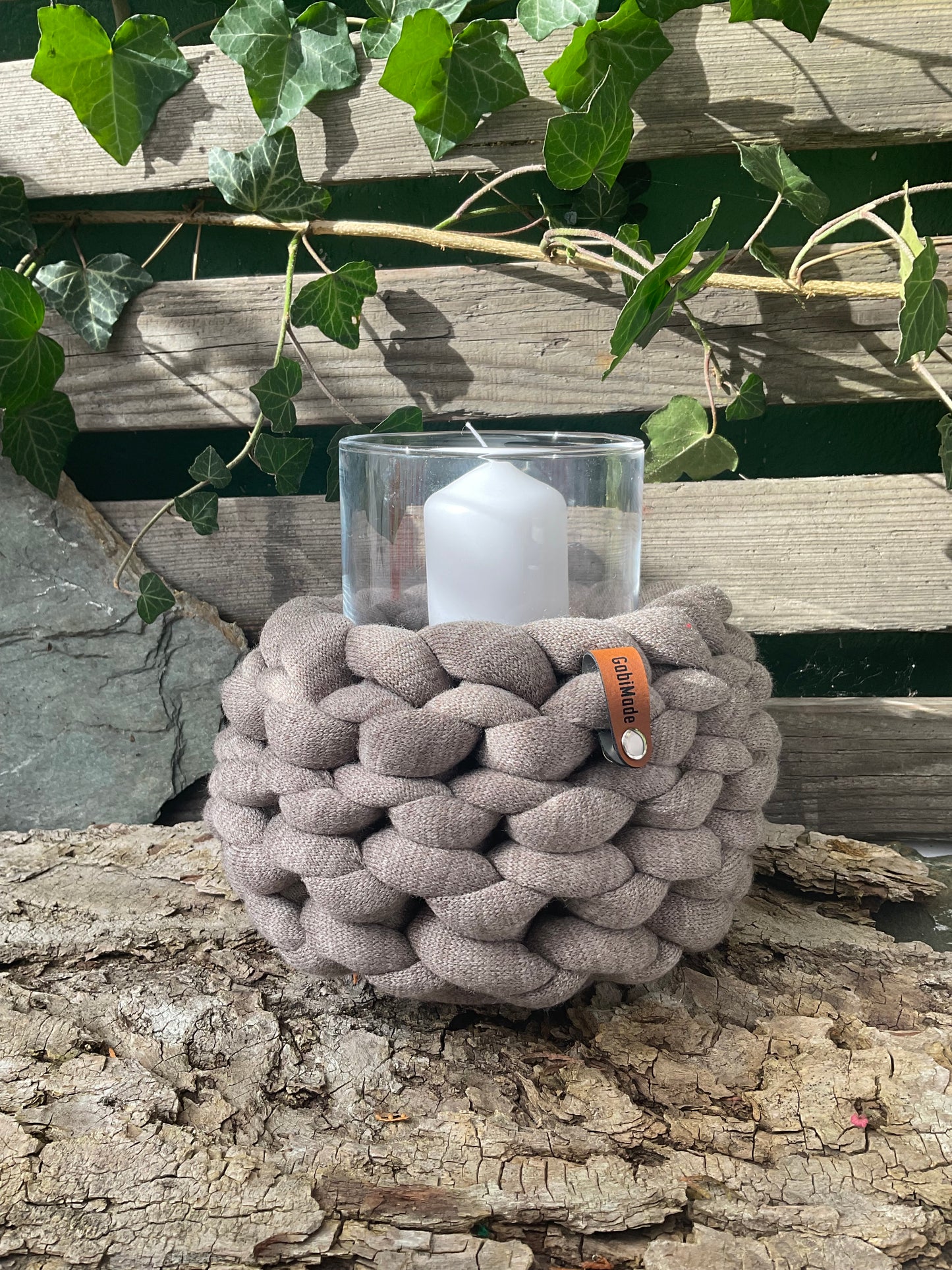 Ein gestricktes braunes Windlicht mit Glaseinsatz