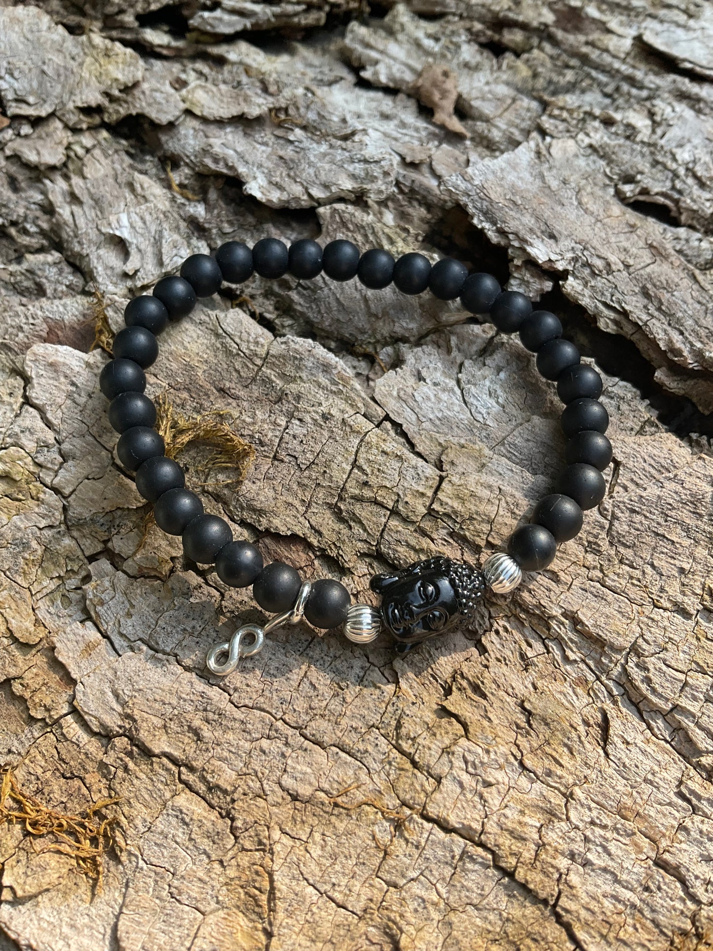 Ein schwarzes Perlenarmband mit Buddha und Anhänger