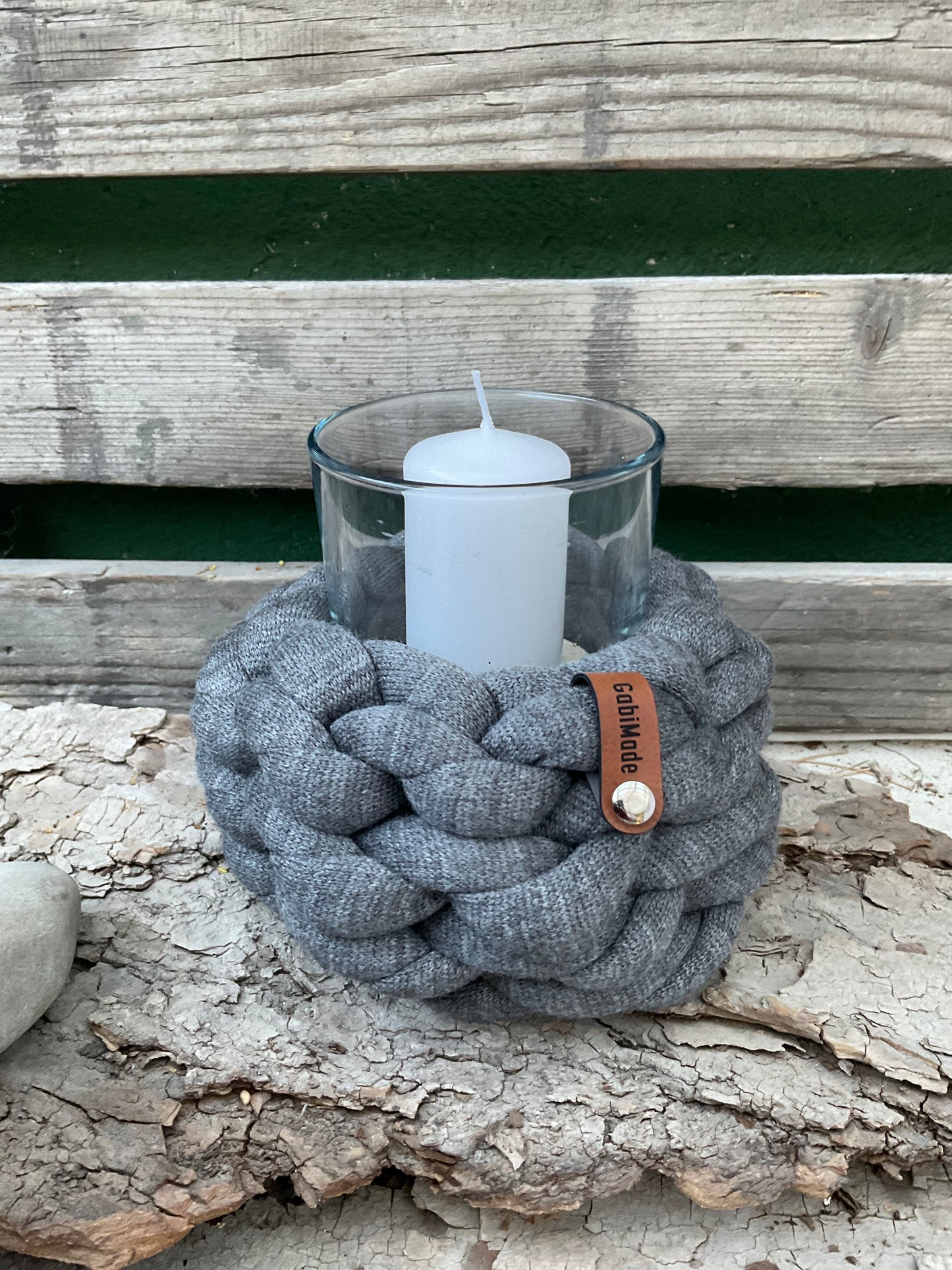 Ein gestricktes graues Mini Windlicht mit Glaseinsatz und Kerze