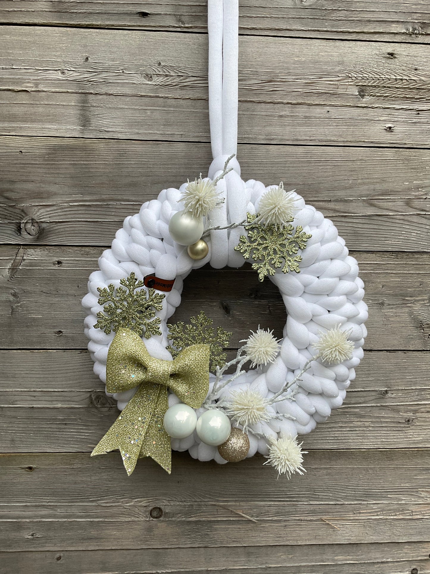 Ein gestrickter weißer geschmückter Türkranz