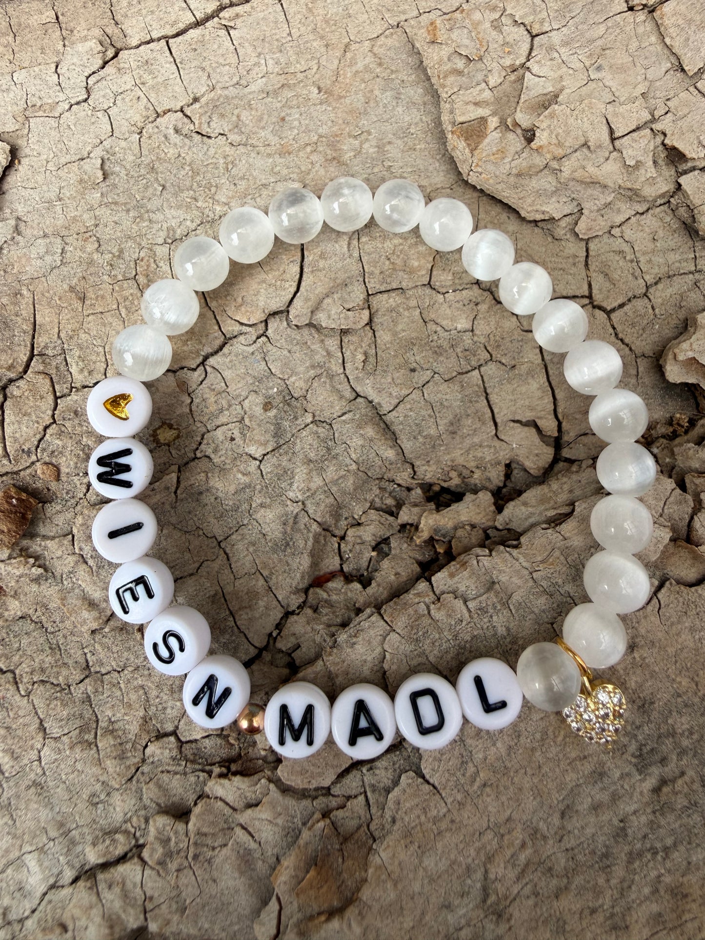 Ein weißes perlenarmband mit WiesnMadl und Herzanhänger