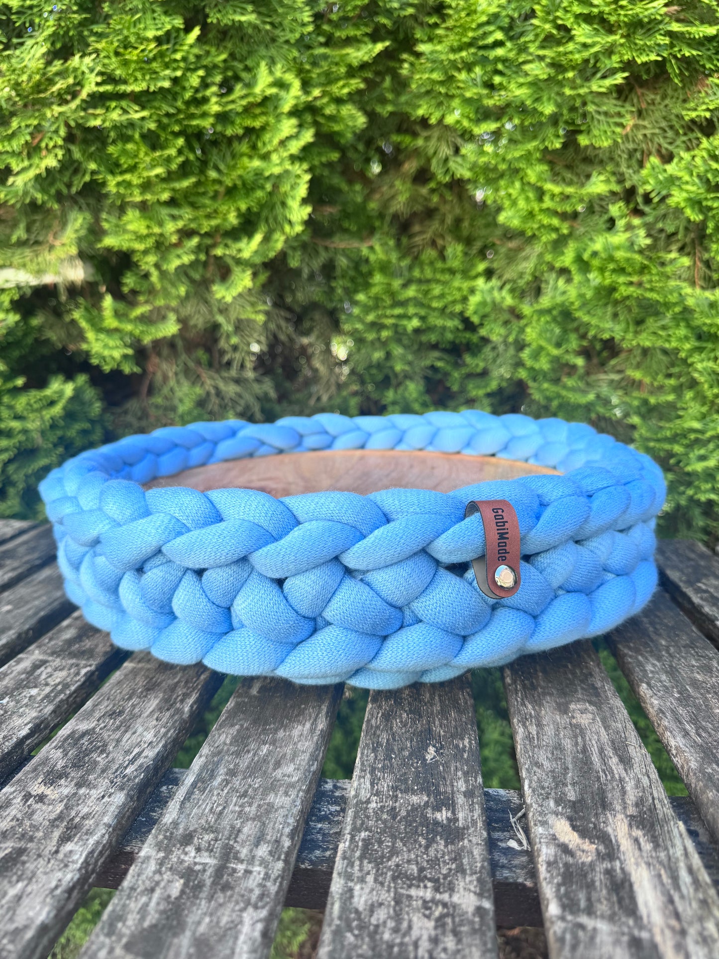 Ein gestricktes Windlicht in Skyblue mit Holzteller in Large.
