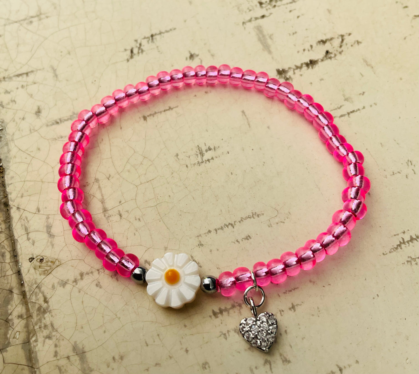 Ein pinkes Perlenarmband mir Glitzer Herzanhänger