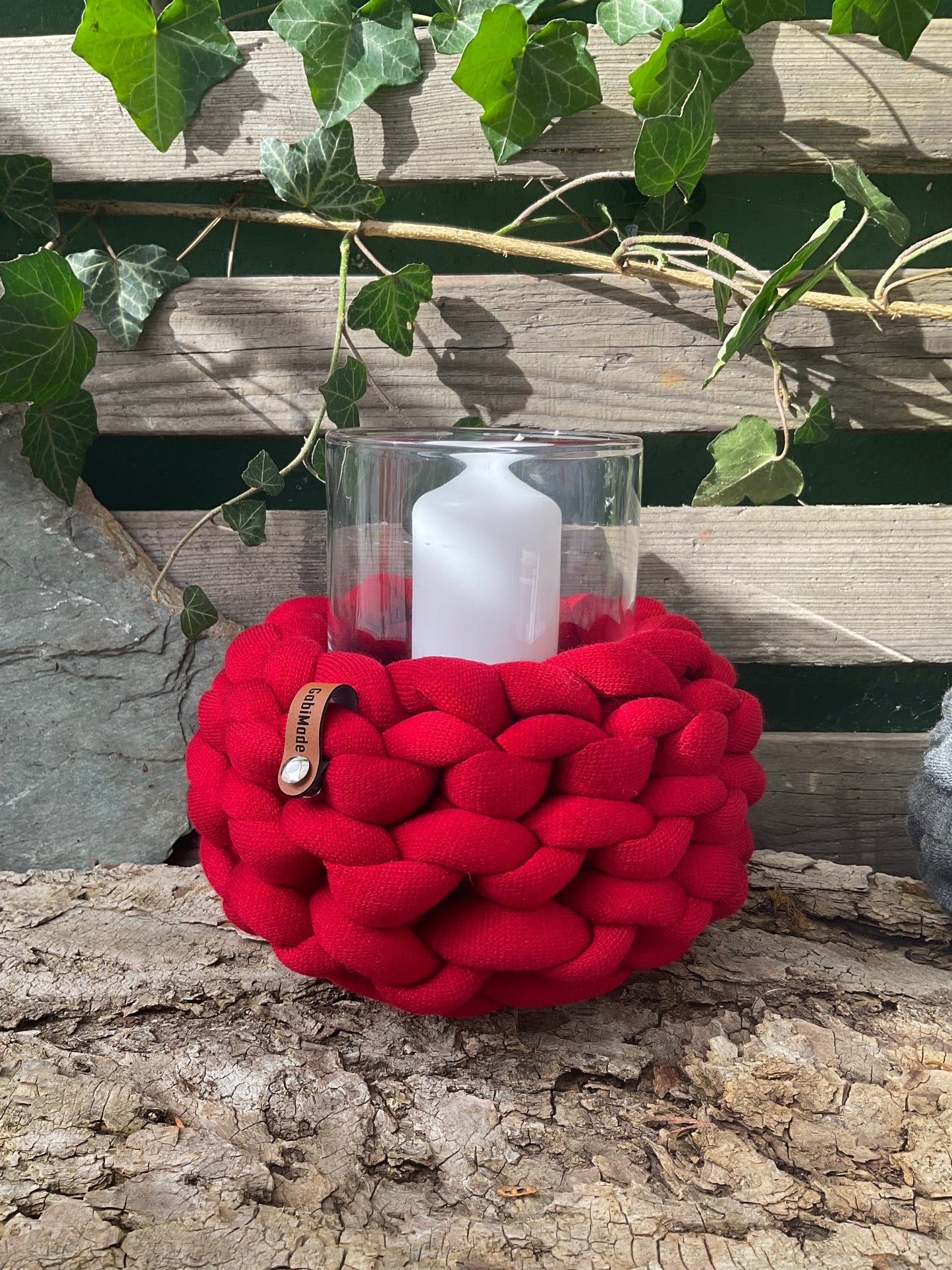 Ein gestricktes rotes Windlicht mit Glaseinsatz