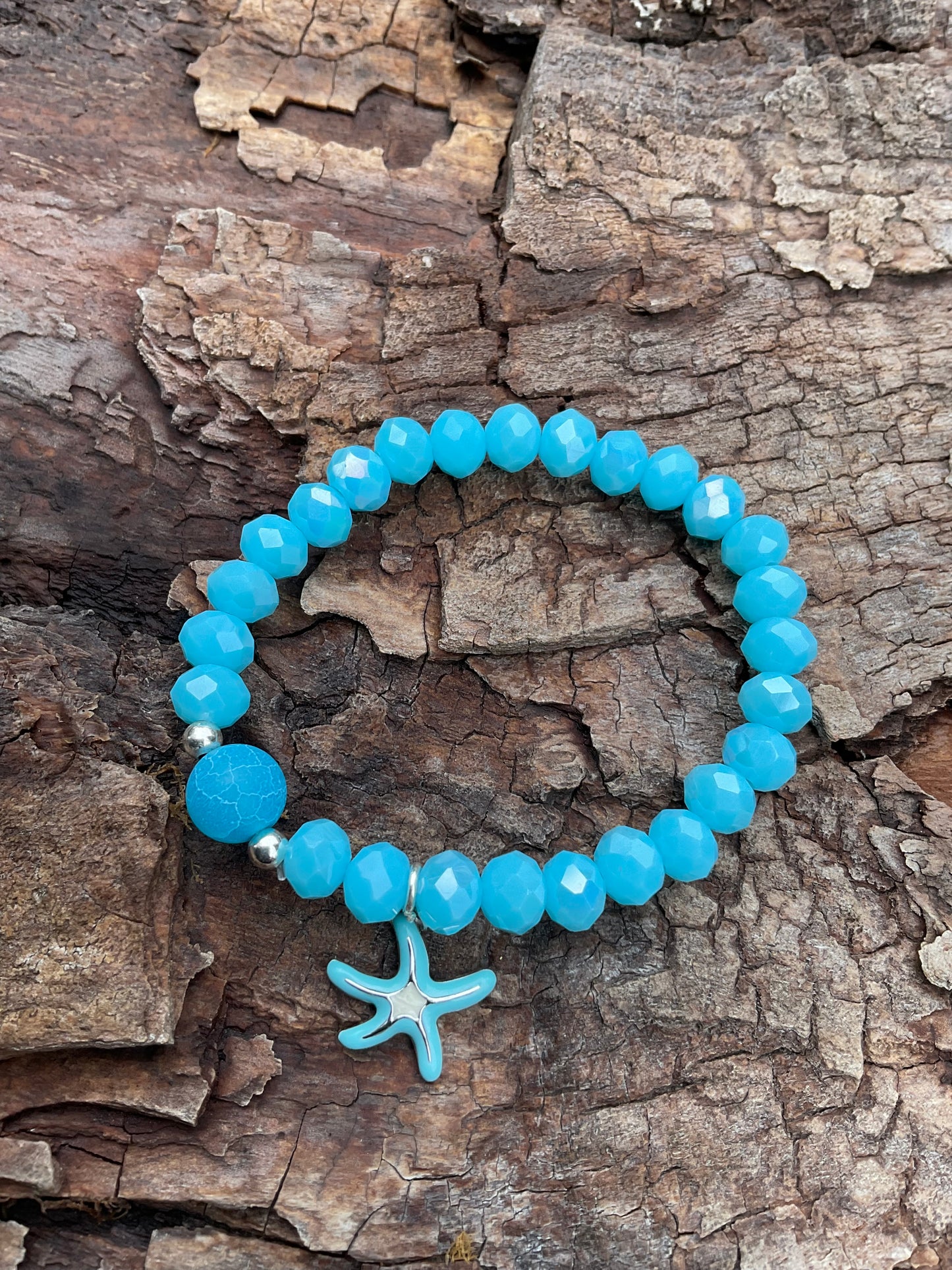 Ein blaues Armband mit einer blauen Perle und einem türkisen Seestern Anhänger