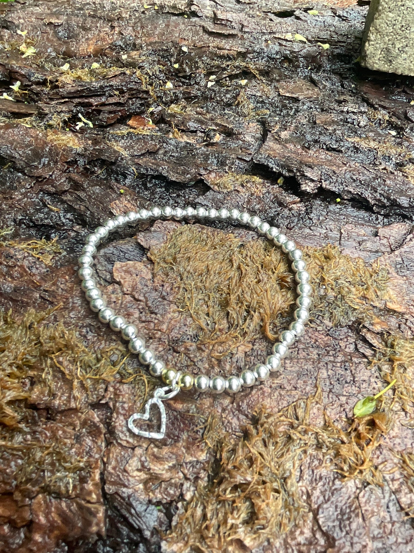 Ein 925 Silberarmband mit einem silbernen Herzanhänger.