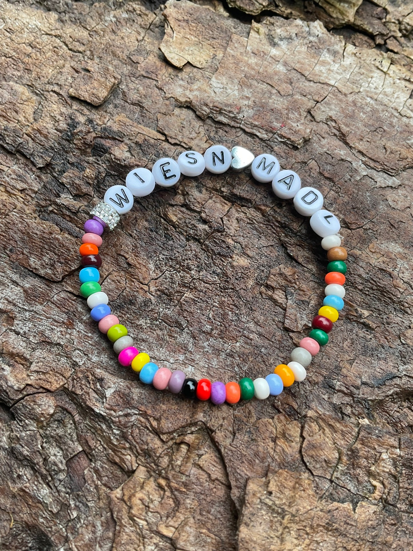 Ein buntes Perlenarmband mit Glitzer und Herz