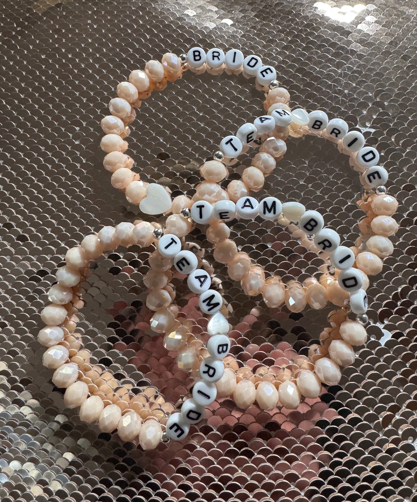 Ein 4er Armband Set in Cremefarben mit den Worten Team Bride und Bride