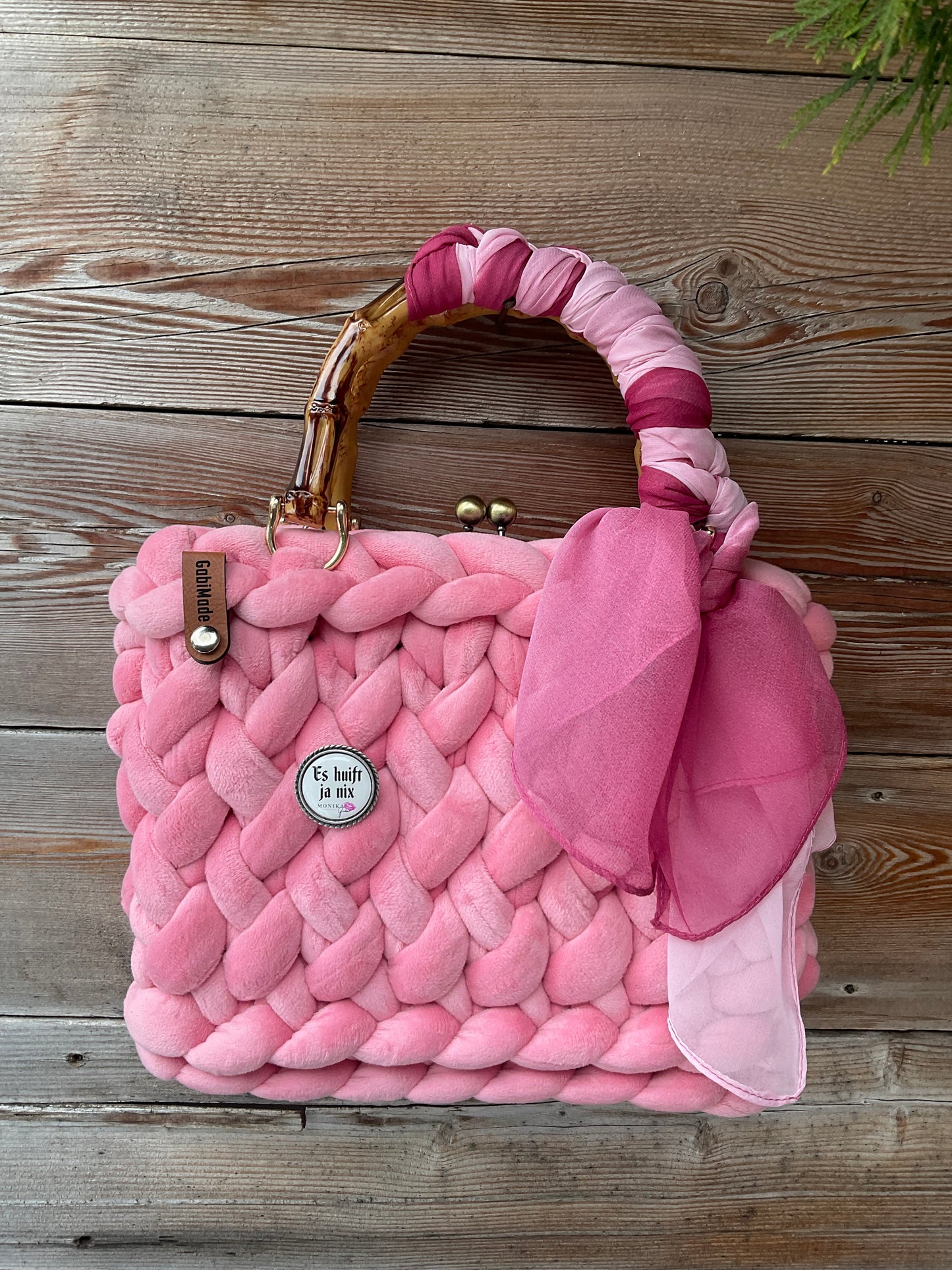 Eine gestrickte rosa trachtentasche mit Brosche 
