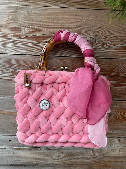 Eine gestrickte rosa trachtentasche mit Brosche 