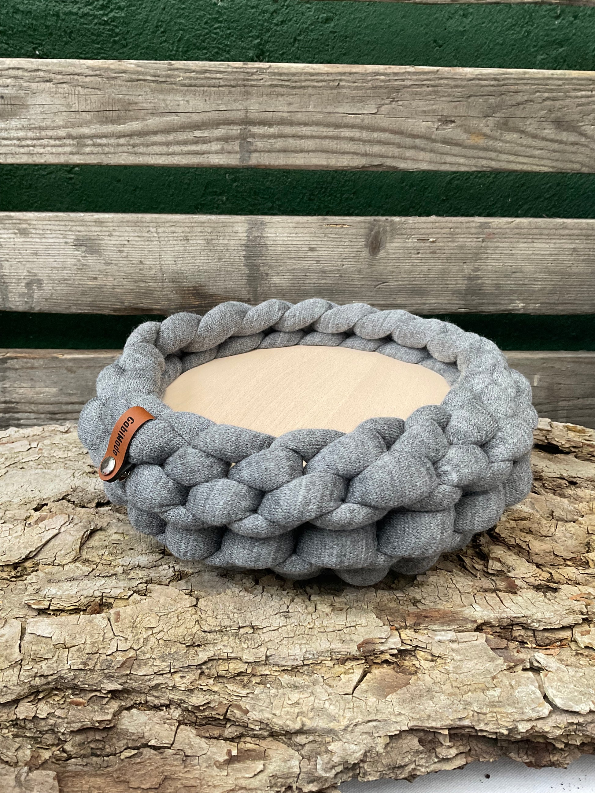 Ein gestricktes graues Tablett mit Holzteller