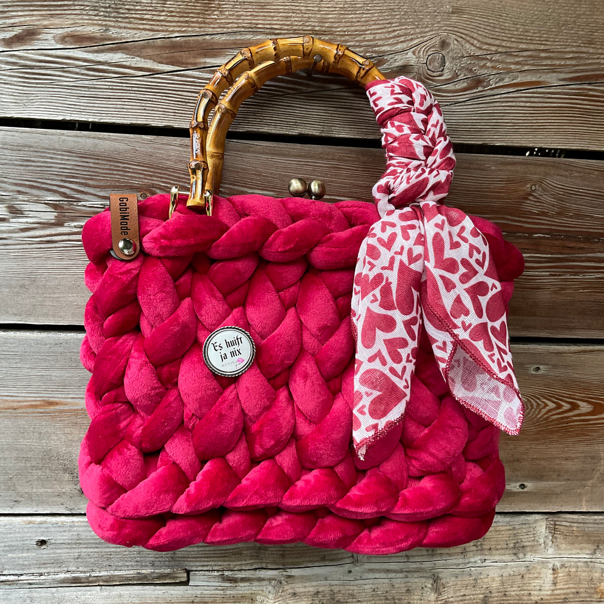 Eine gestrickte Trachtentasche mit Gaudiknopf und Bambusgriffen 
