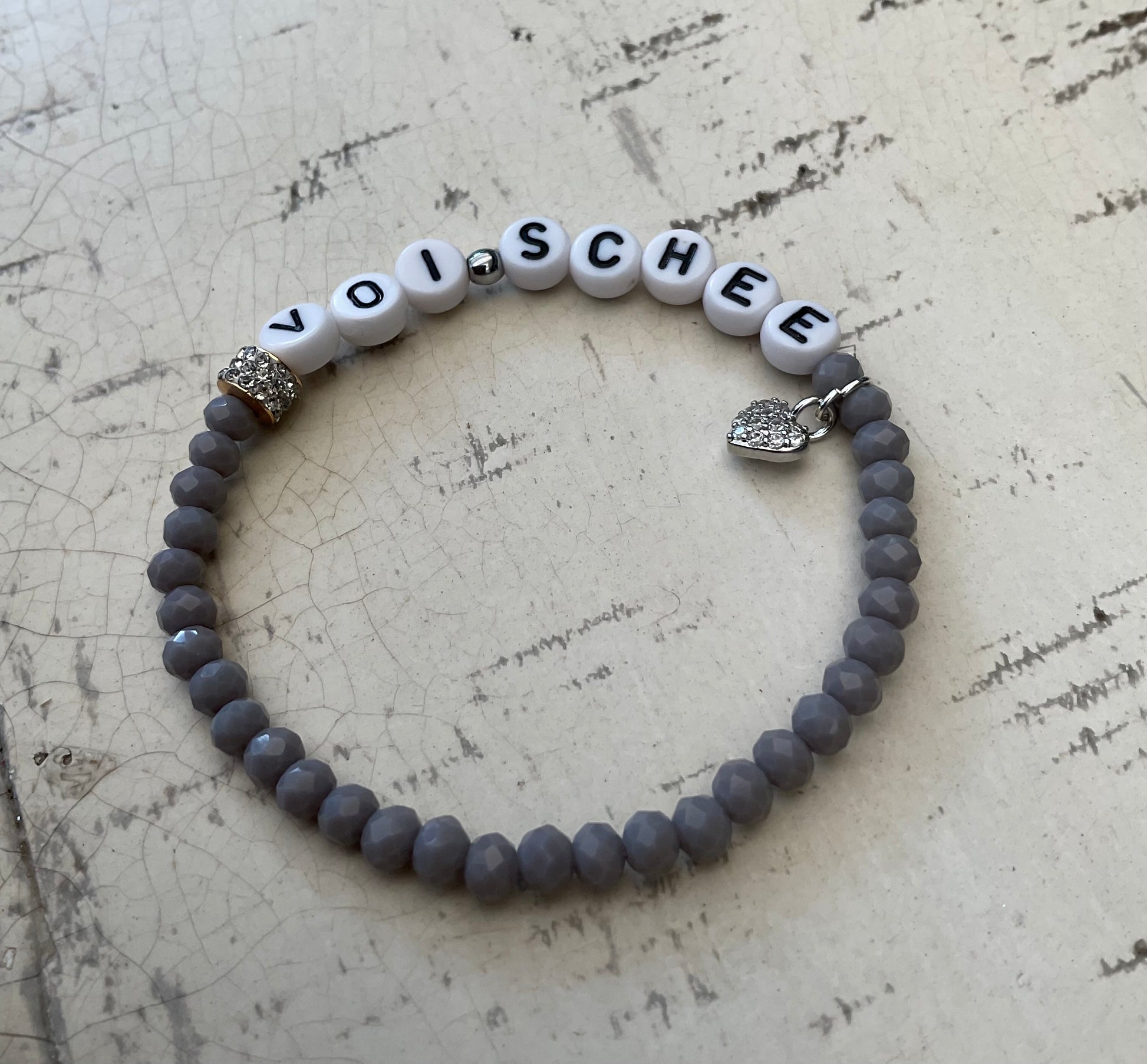 Ein graues perlenarmbandvmit Glitzerherz