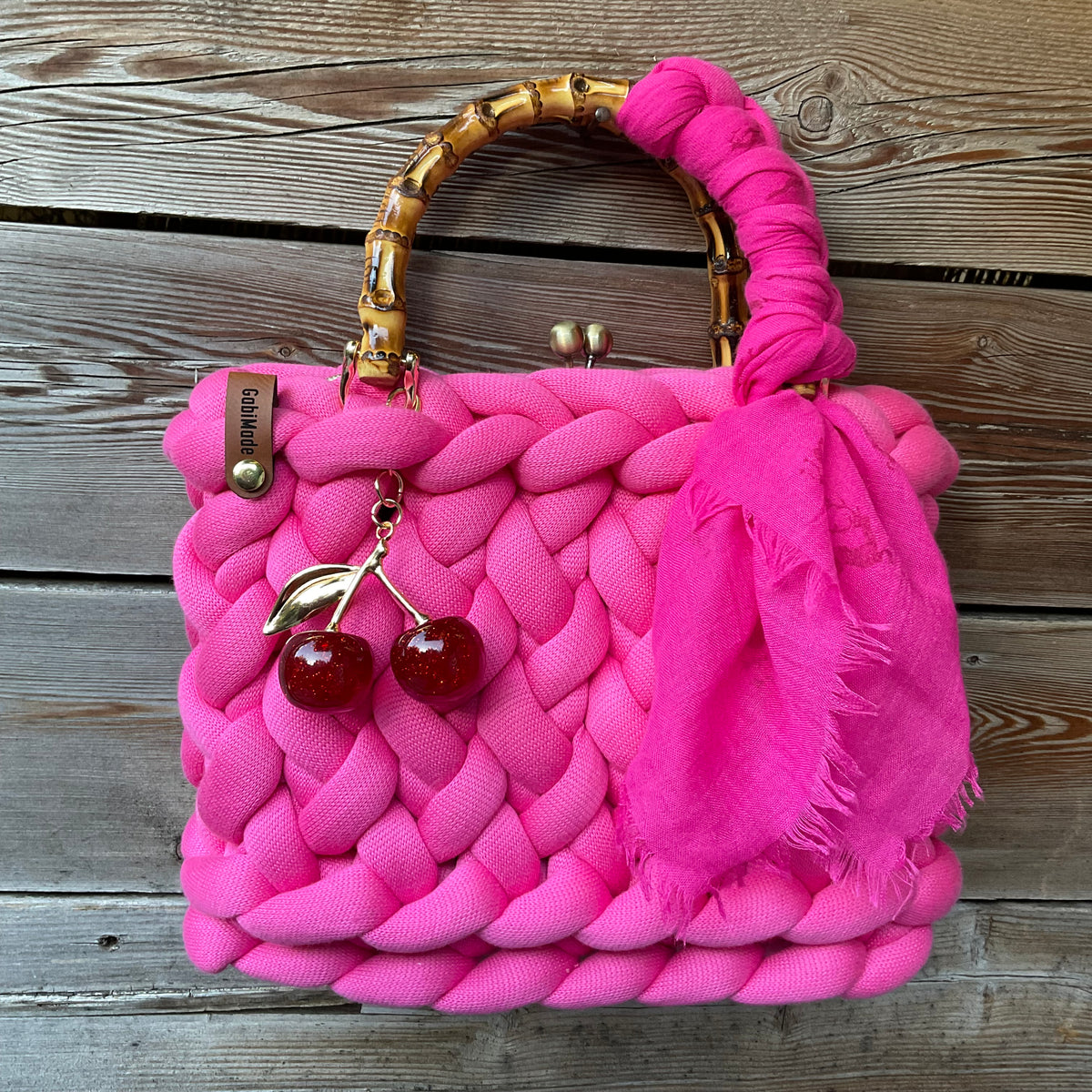 Eine gestrickte Pinke Trachtentasche mit Bambusgriffen 