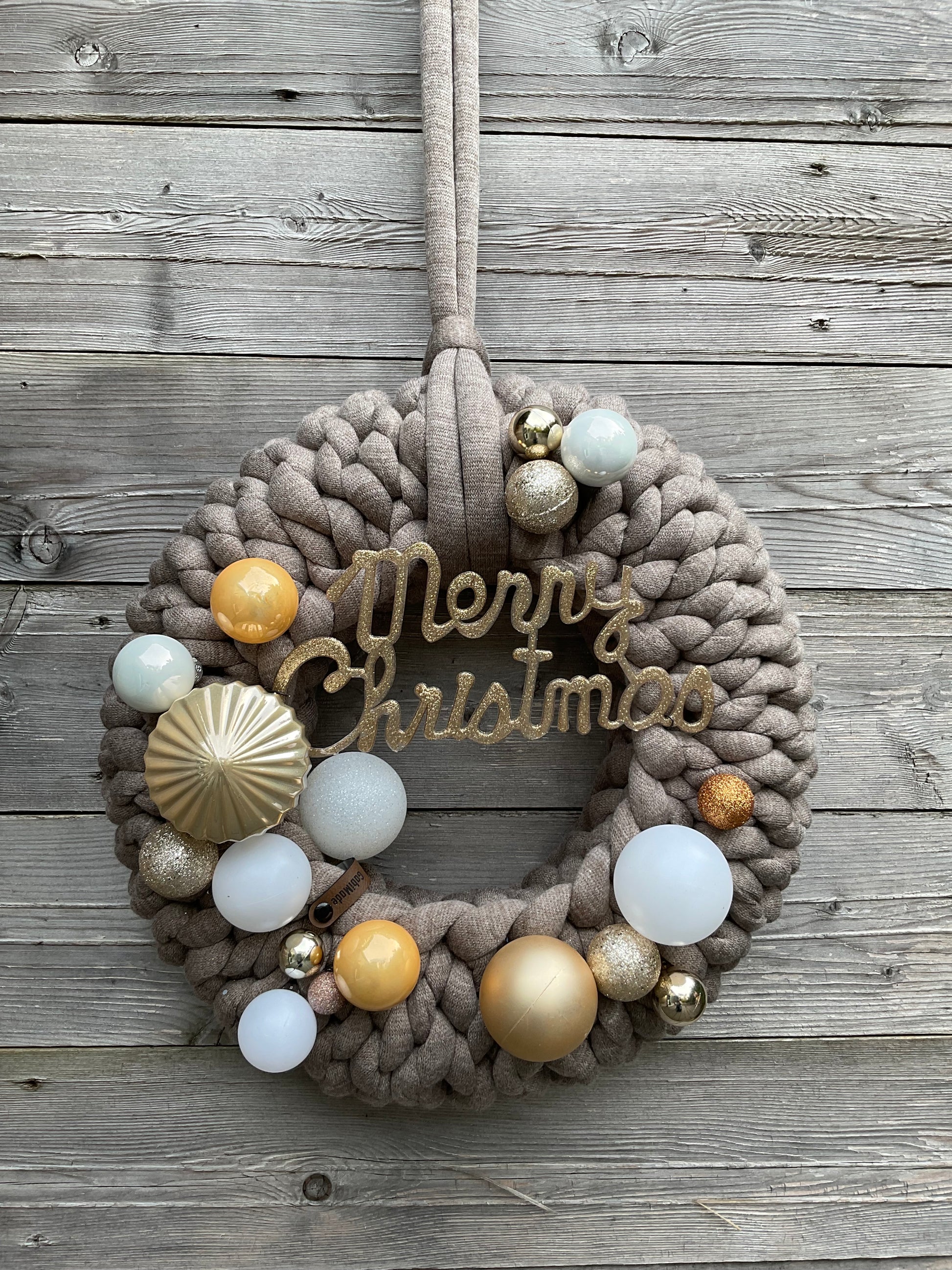 Ein gestrickter brauner geschmückter Türkranz 