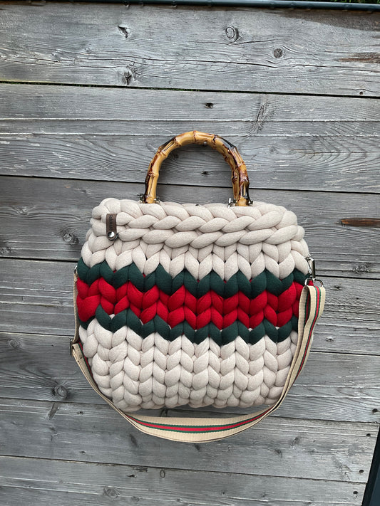 Eine gestrickte Tasche mit Streifen und Bambusgriffen 