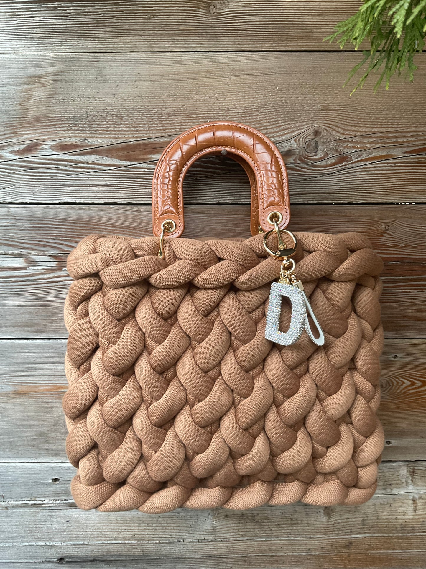Eine gestrickte Tasche in braun mit Henkeln 