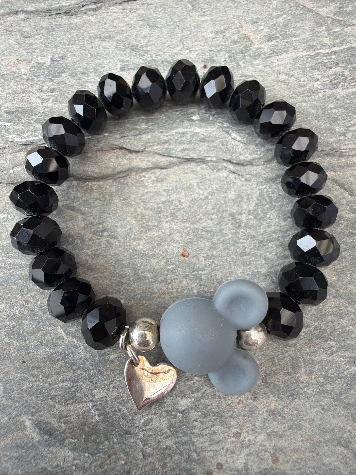 Ein schwarzes Perlenarmband mit grauer Maus 