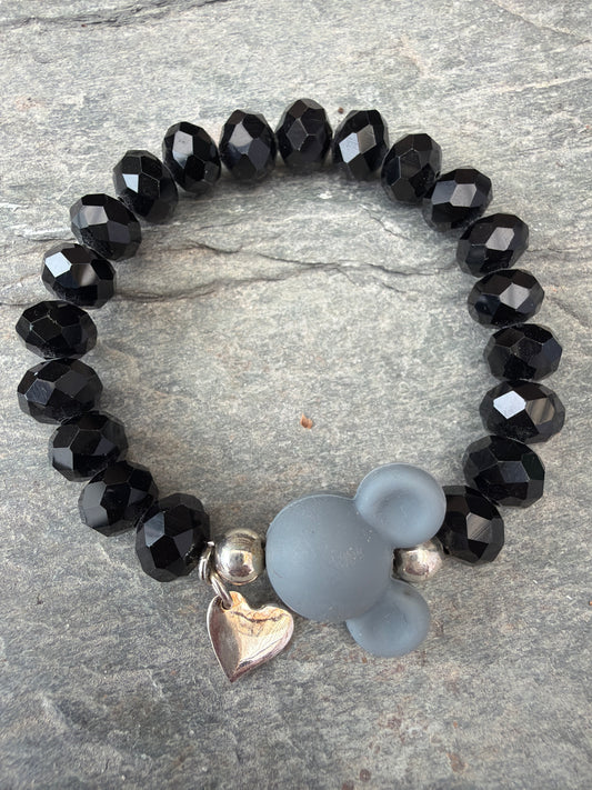 Ein schwarzes Perlenarmband mit grauer Maus 