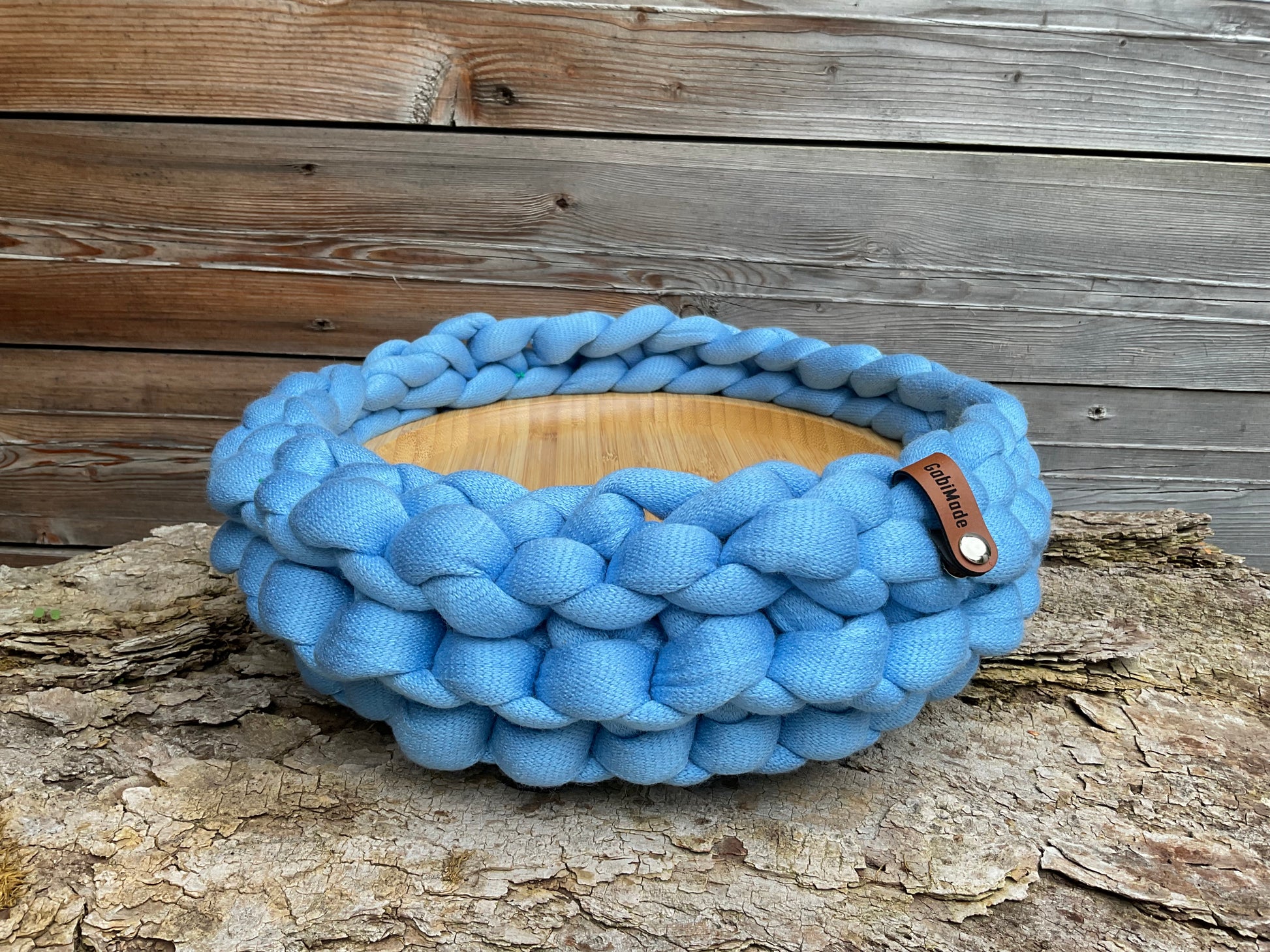 Ein gestricktes blaues Tablett mit Holzbrett