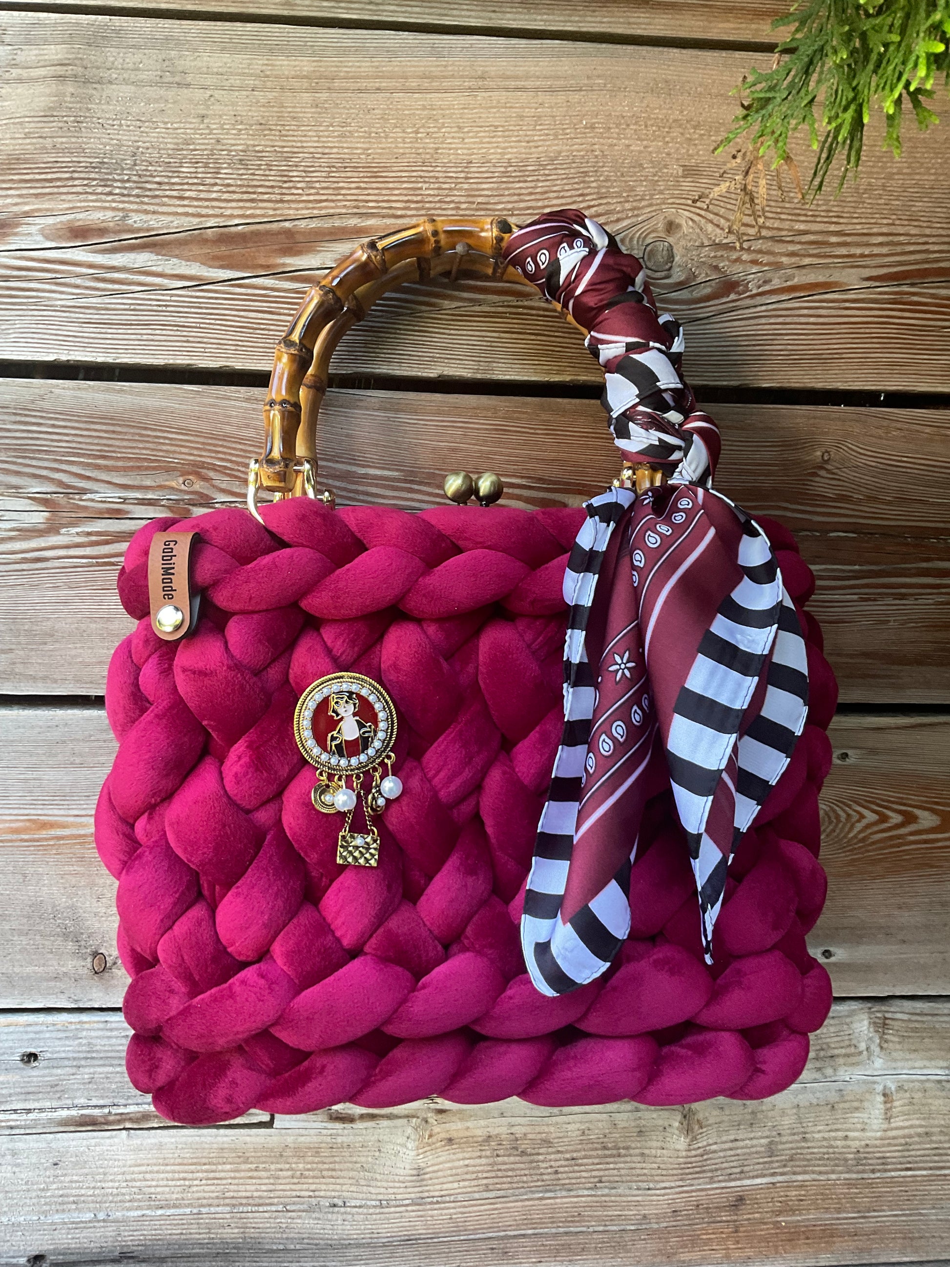 Eine Bordeaux Trachtentasche mit Brosche und Tuch