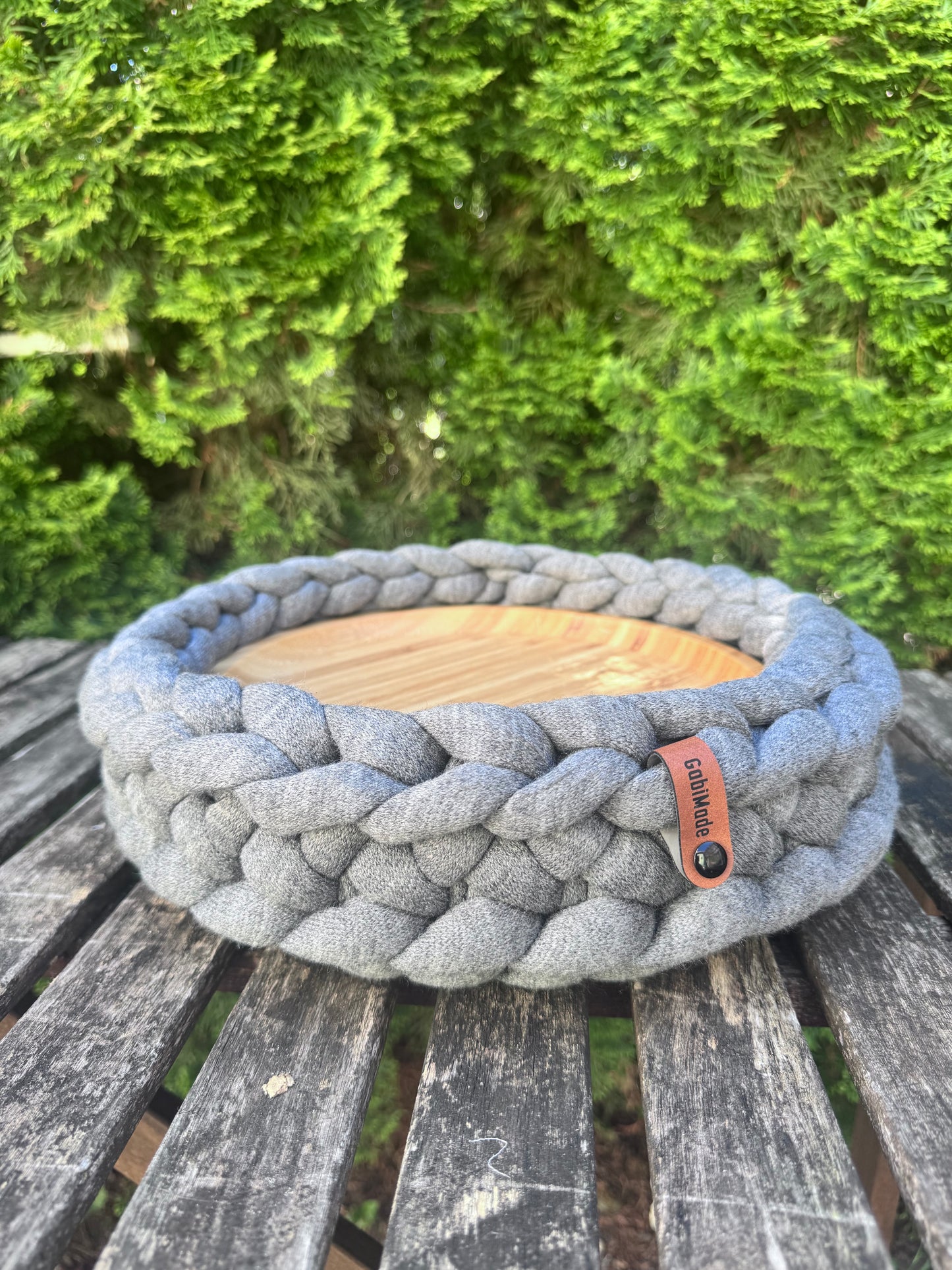 Ein gestricktes graues Tablett mit Holzteller in Medium.