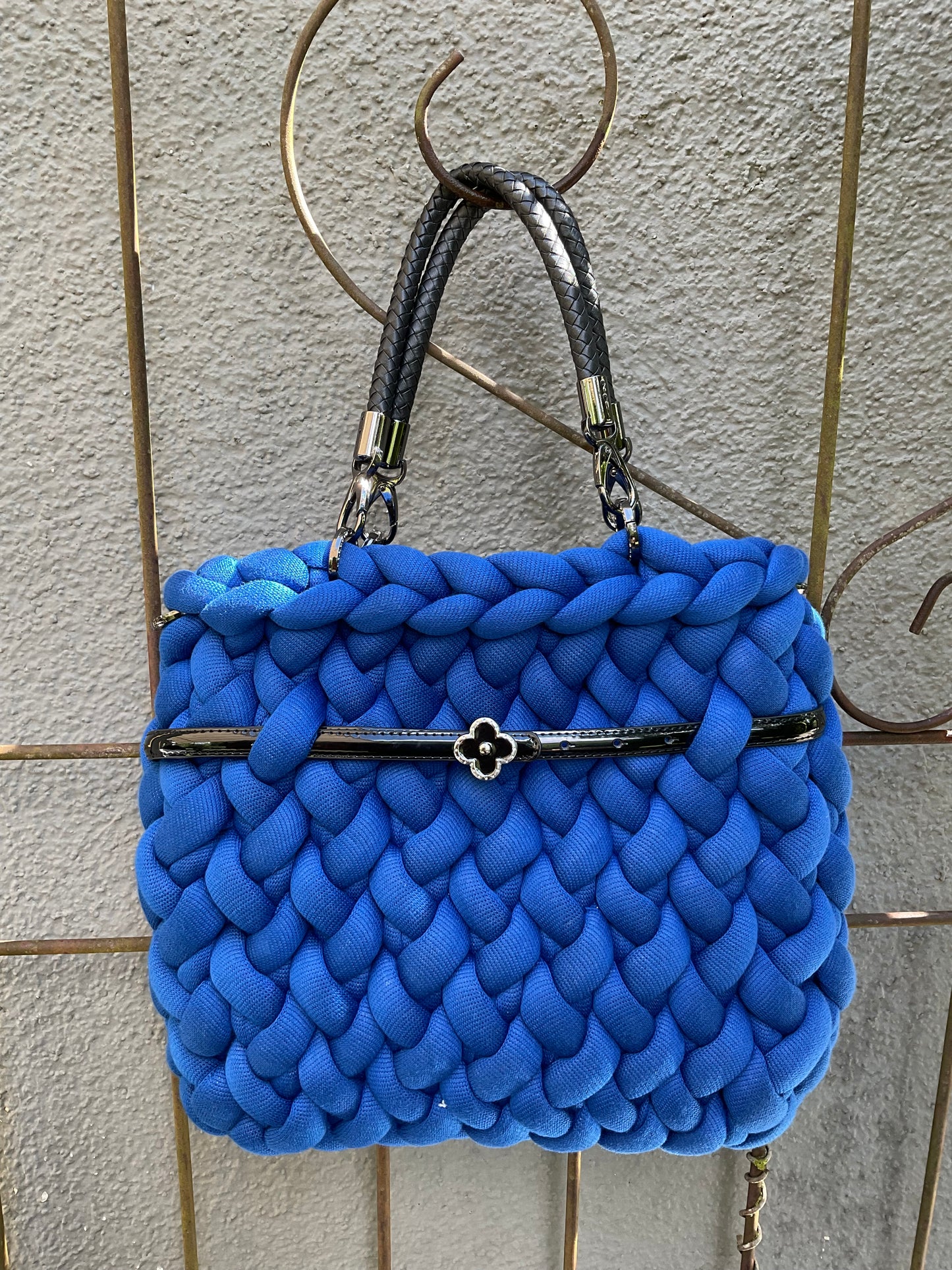 Eine gestrickte blaue Tasche mit Kunstleder Griffen