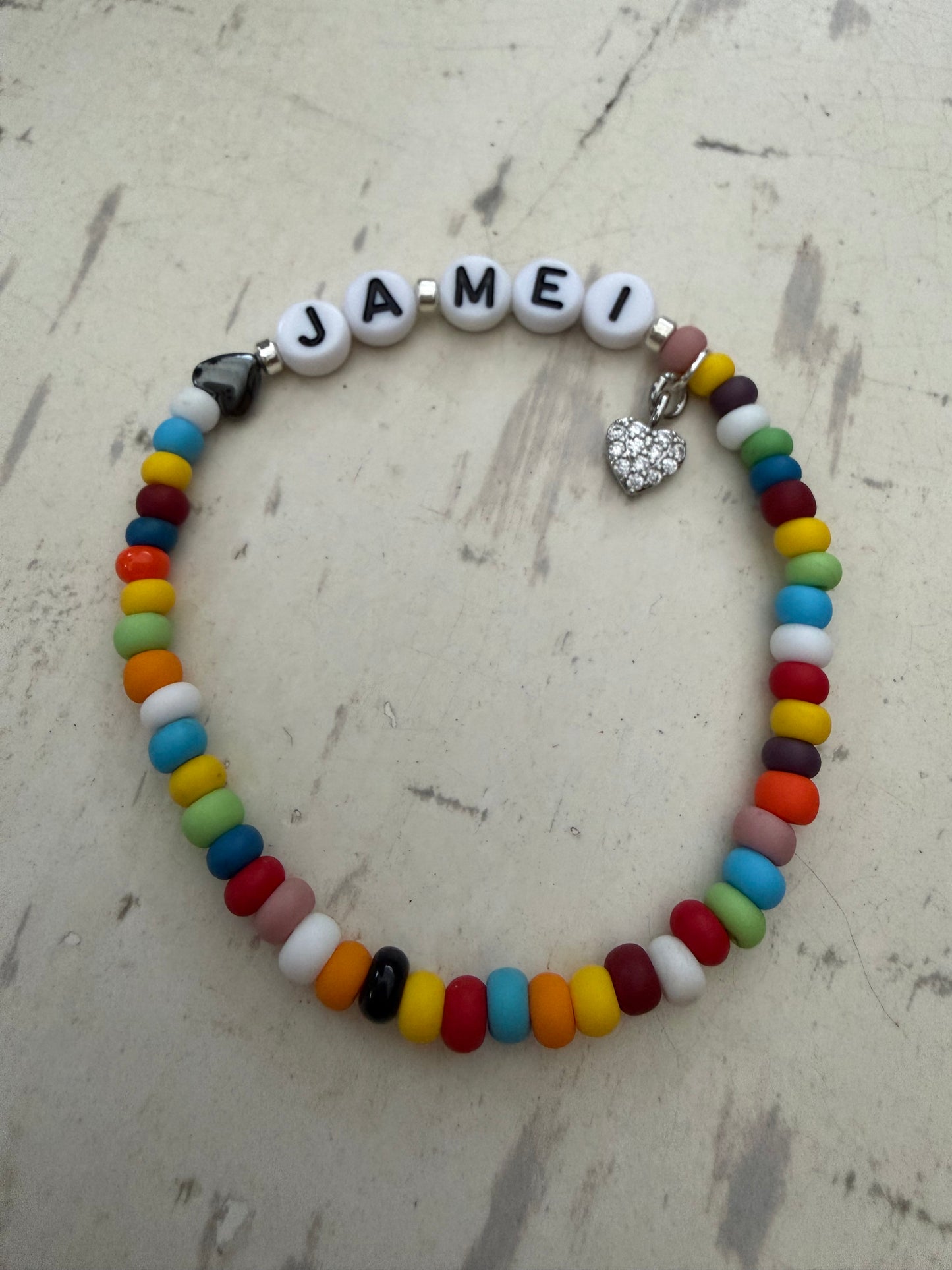 Ein buntes Perlenarmband mit Herz und ja Mei 