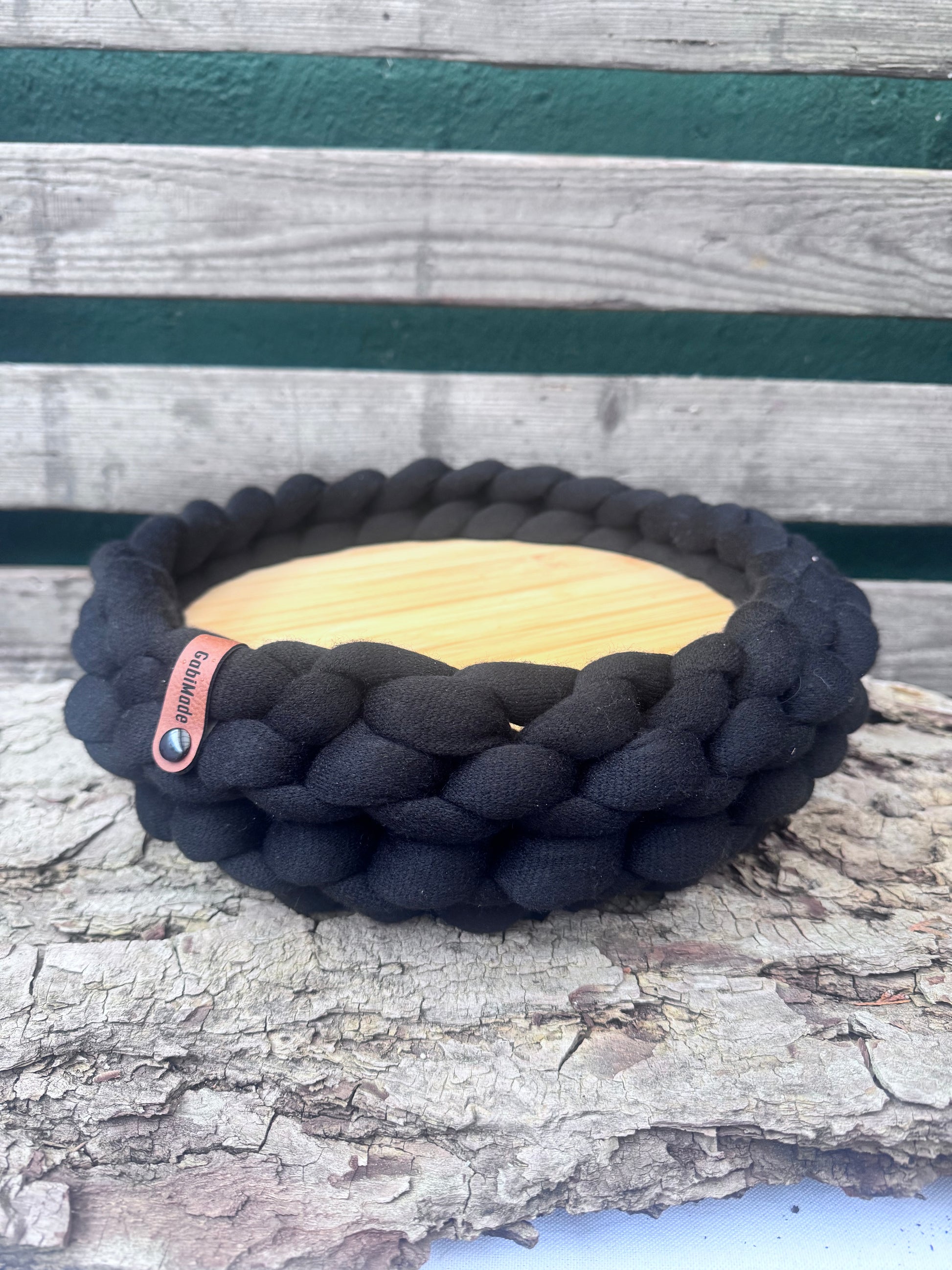 Ein getricktes Tablett in schwarz mit Holzteller 